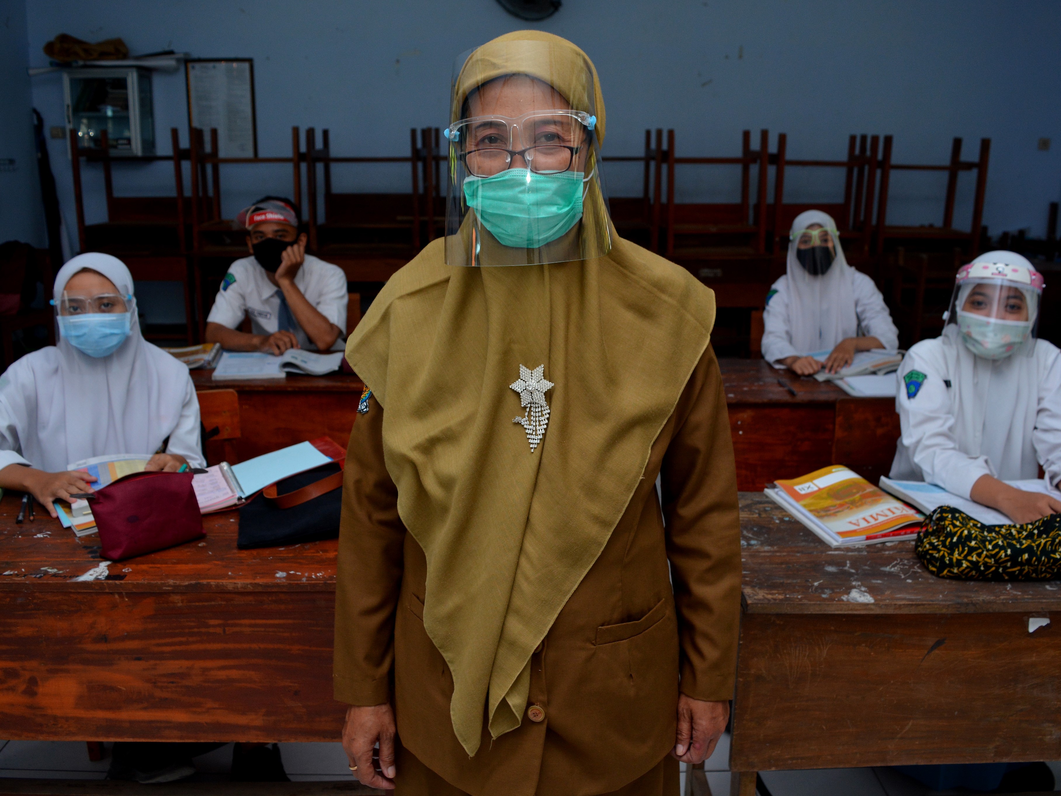 Guru berpose bersama siswanya usai kegiatan belajar mengajar tatap muka terbatas di SMA Negeri 3, Kabupaten Jombang, Jawa Timur.