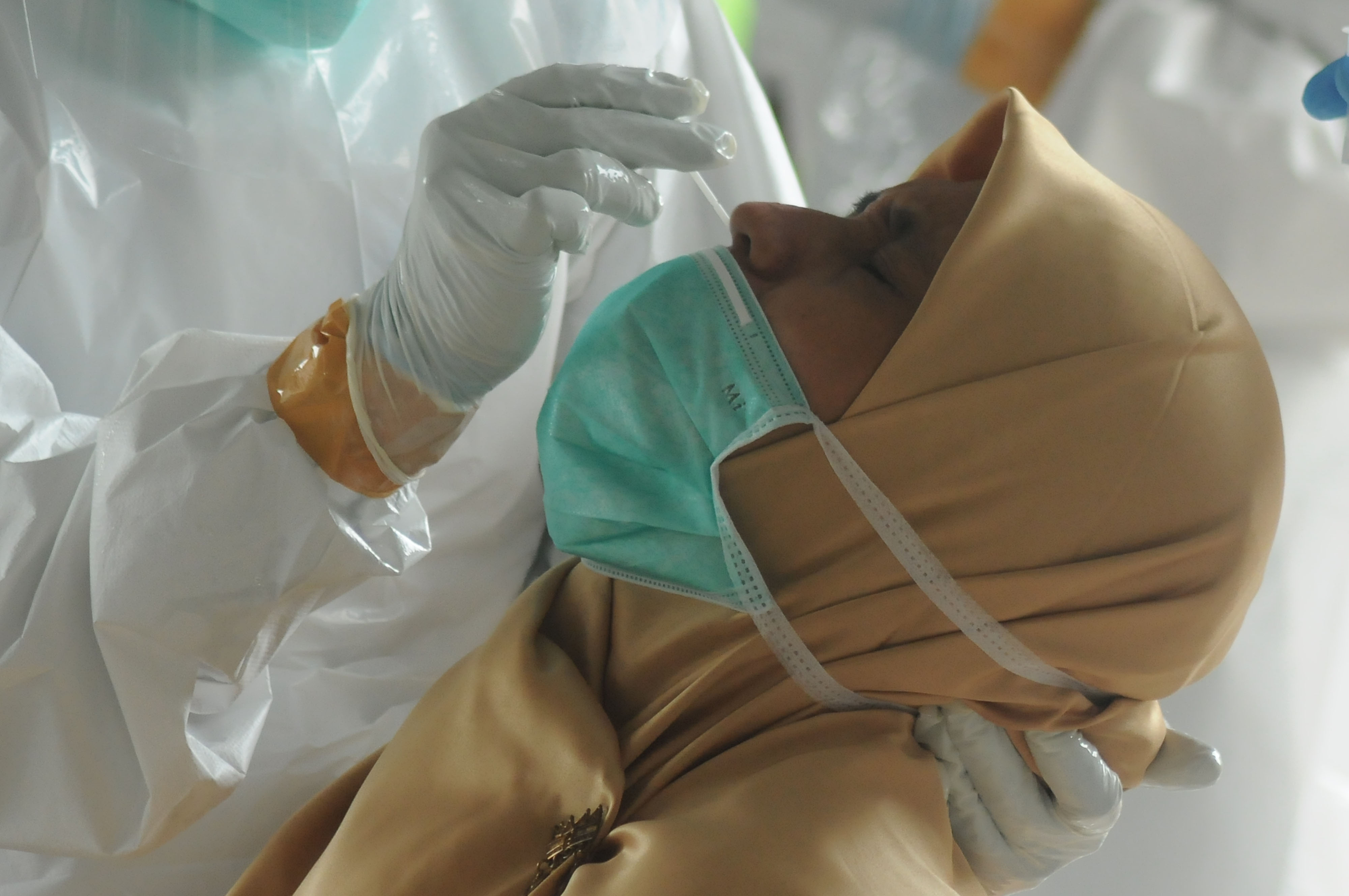 TES CEPAT ANTIGEN: Petugas kesehatan mengambil sampel lendir hidung untuk dites. Pemerintah telah menurunkan harga tes cepat antigen.