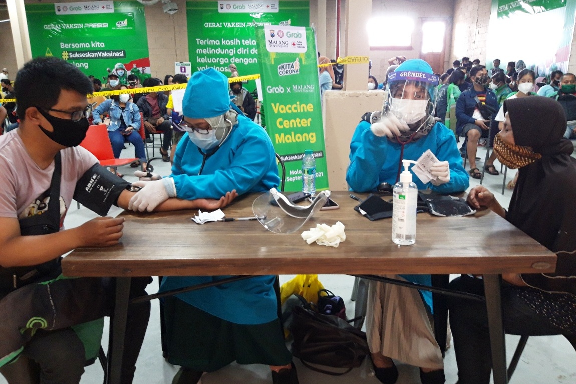 Driver ojek daring dan pengunjung mal menerima vaksinasi di Malang Town Square (Matos), Kota Malang, Jawa Timur, Minggu (5/9).