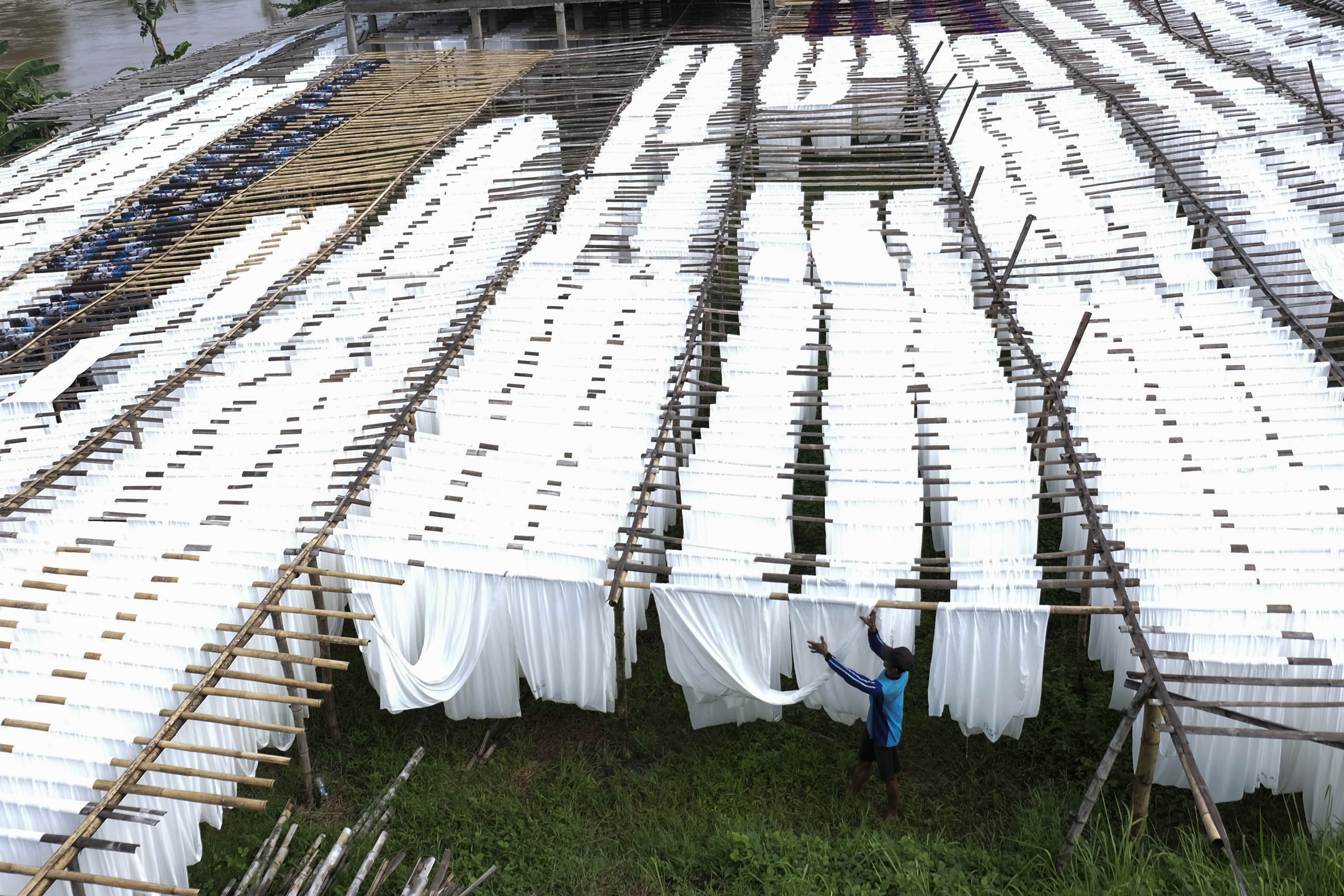 Pekerja menjemur kain rayon untuk bahan busana bermotif dan kain pantai di Mojolaban, Sukoharjo, Jawa Tengah.