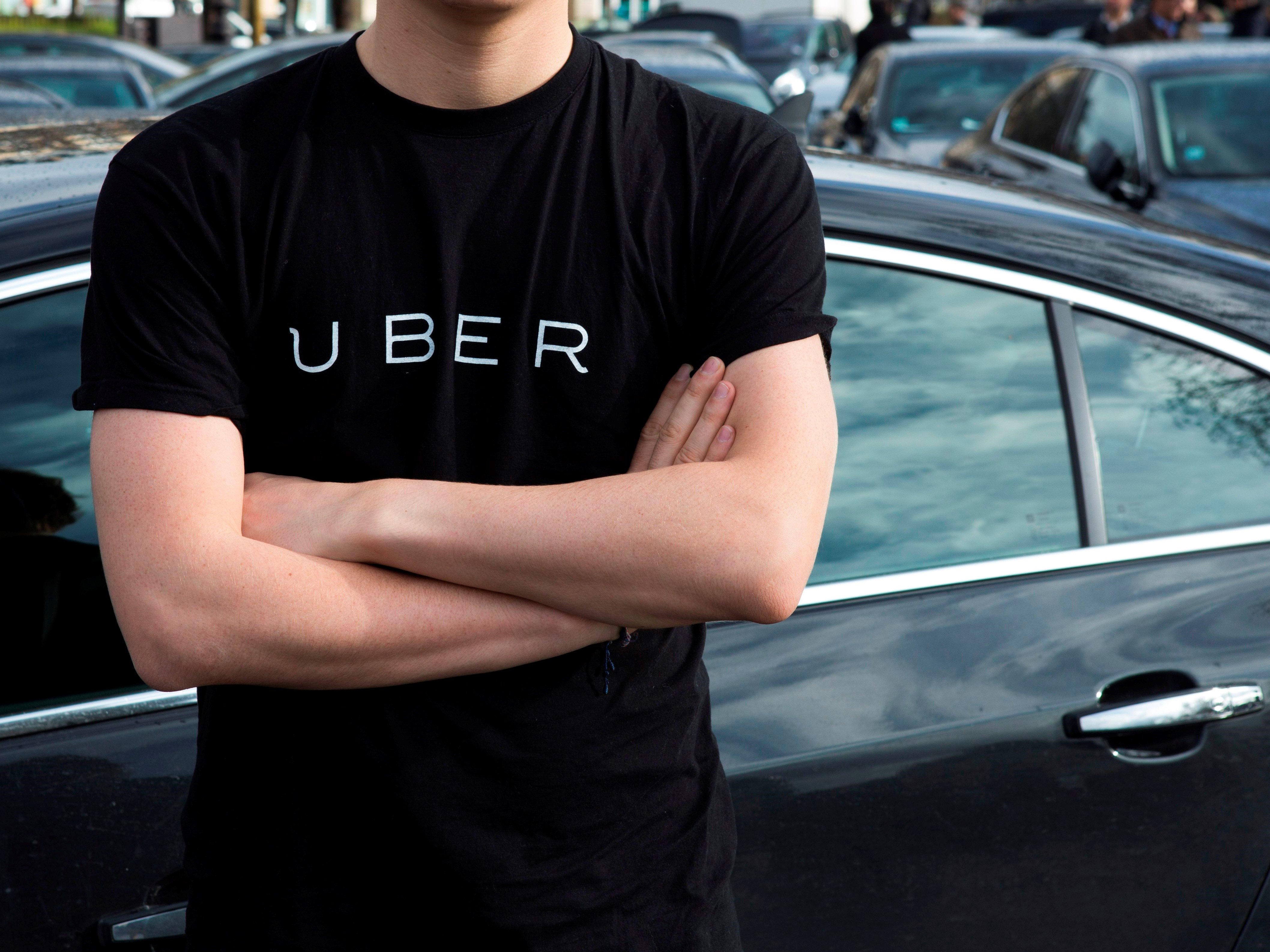 Seorang pengunjuk rasa mengenakan kemeja yang menampilkan logo layanan perjalanan smartphone Uber selama protes oleh pengemudi taksi.