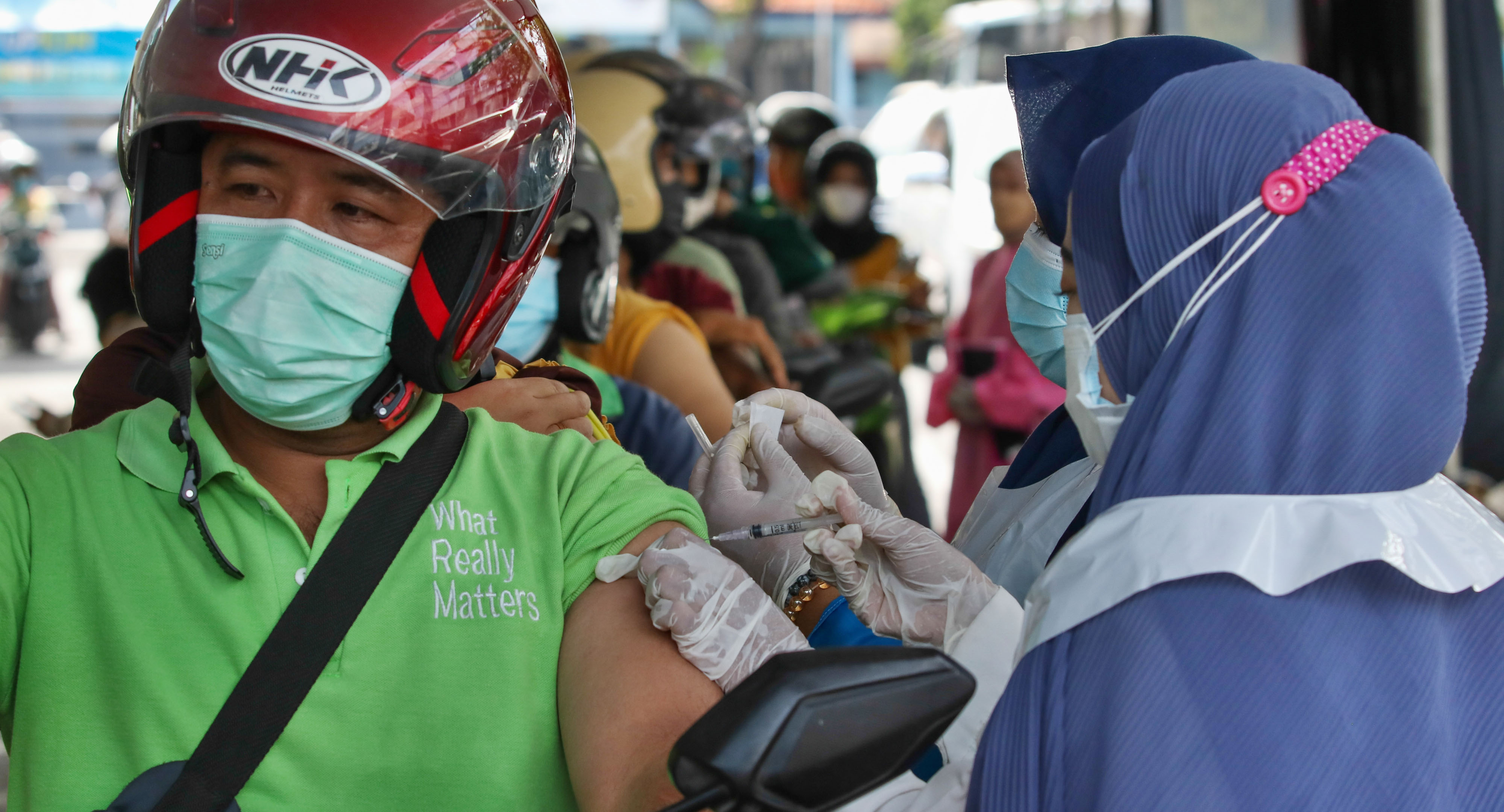 Petugas menyuntikkan vaksin covid-19 pada pengendara motor di Polres Pelabuhan Tanjung Perak Surabaya, Jawa Timur, Sabtu (11/9/2021)