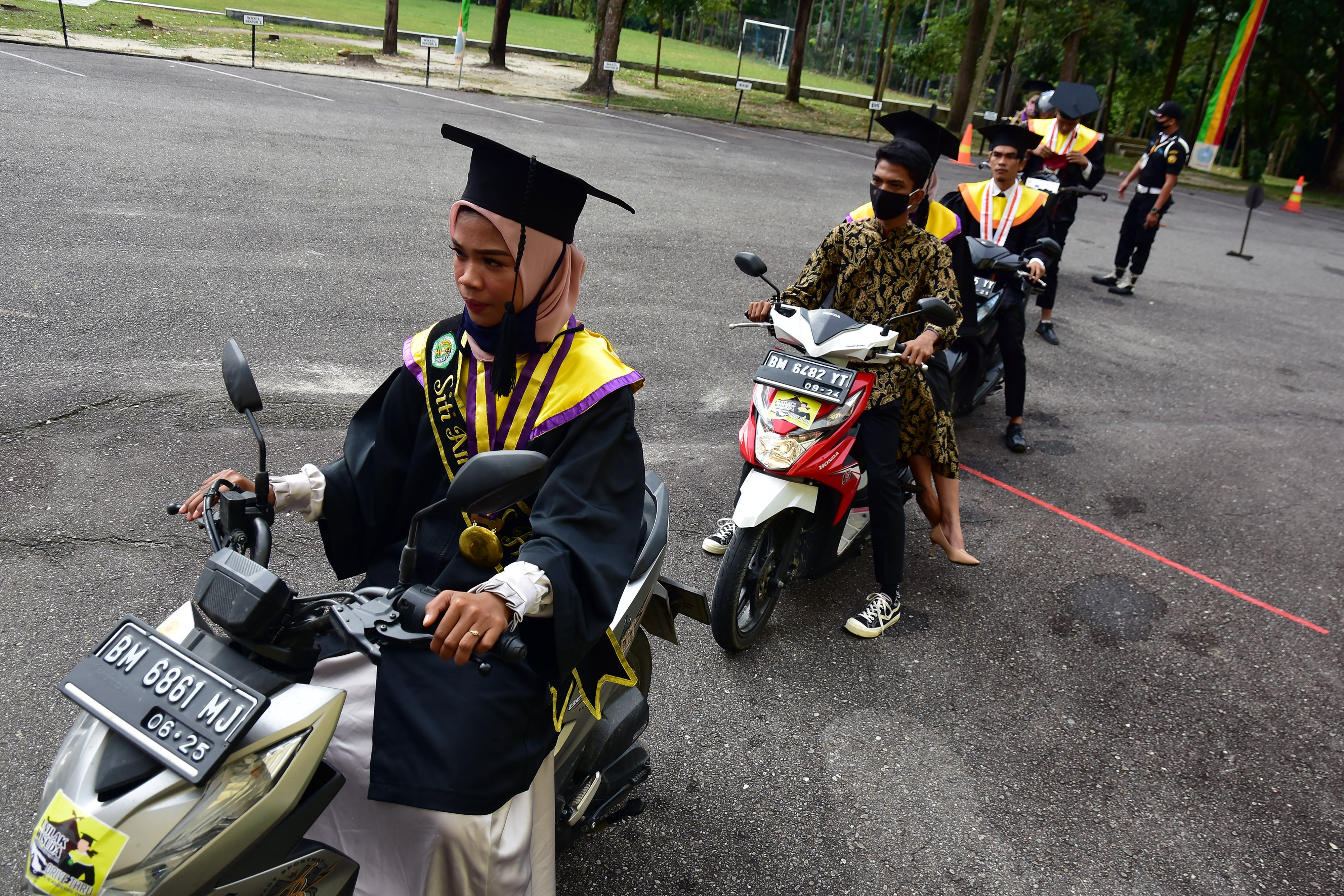 Sejumlah mahasiswa mengantre menggunakan motor untuk wisuda 
