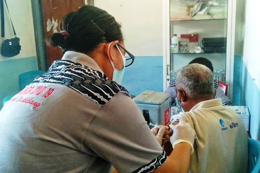 Seorang guru sedang divaksin.