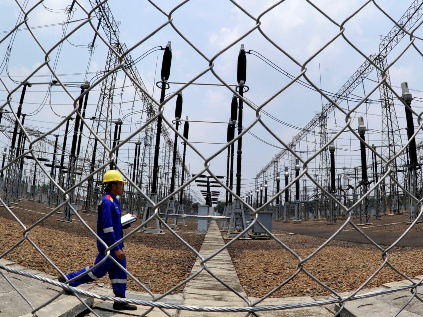 Seorang petugas melakukan inspeksi peralatan di switchyard Gardu Induk Tegangan Ekstra Tinggi (GITET) 500kV Gandul, Depok.