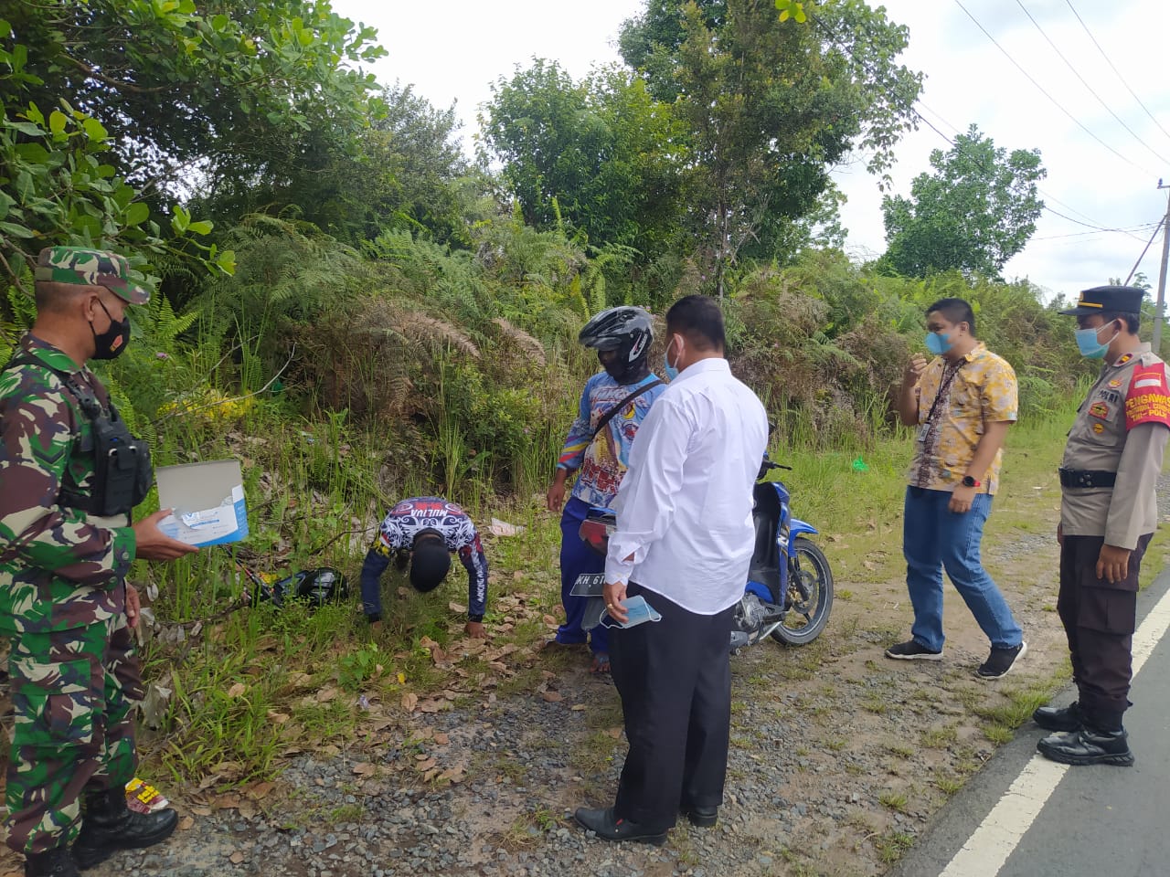 Petugas menghukum seorang warga di Palangka Raya, Kalimantan Tengah,karena melanggar prokes