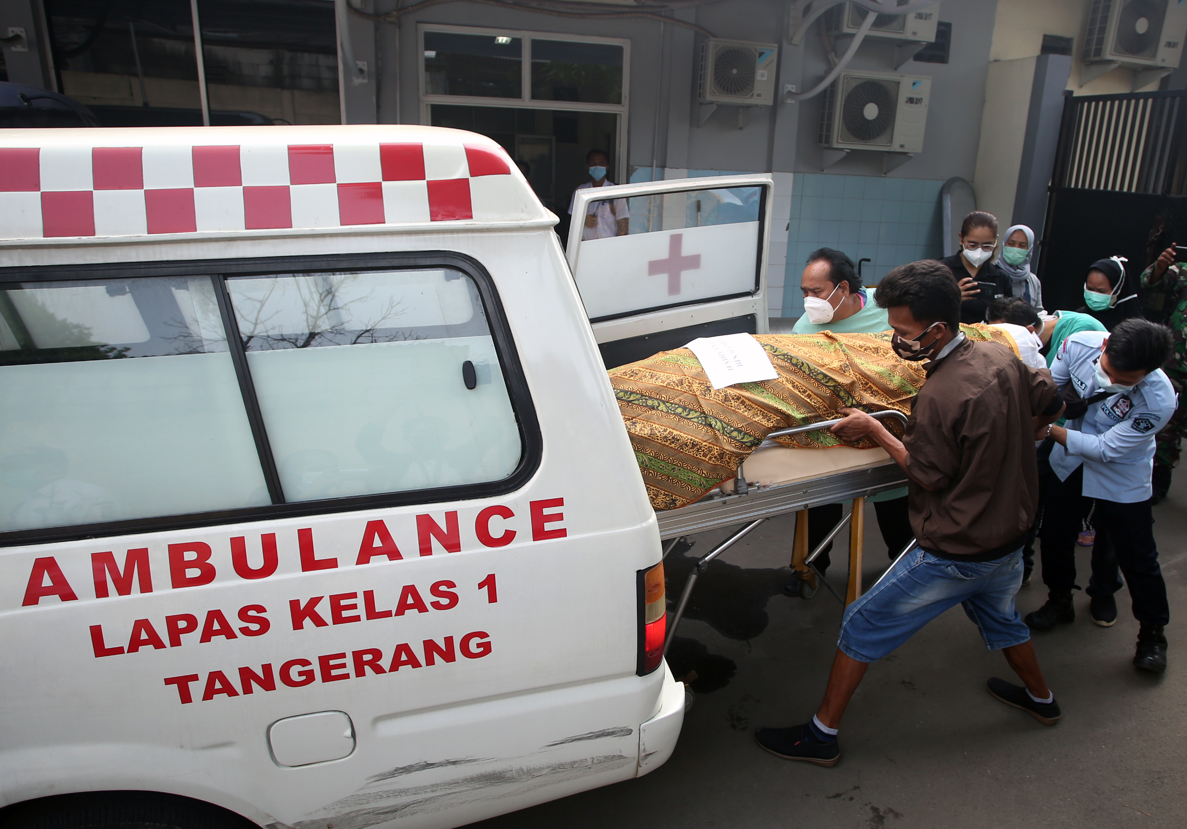 Petugas memasukkan jenazah korban kebakaran Lapas Tangerang ke dalam mobil ambulance.