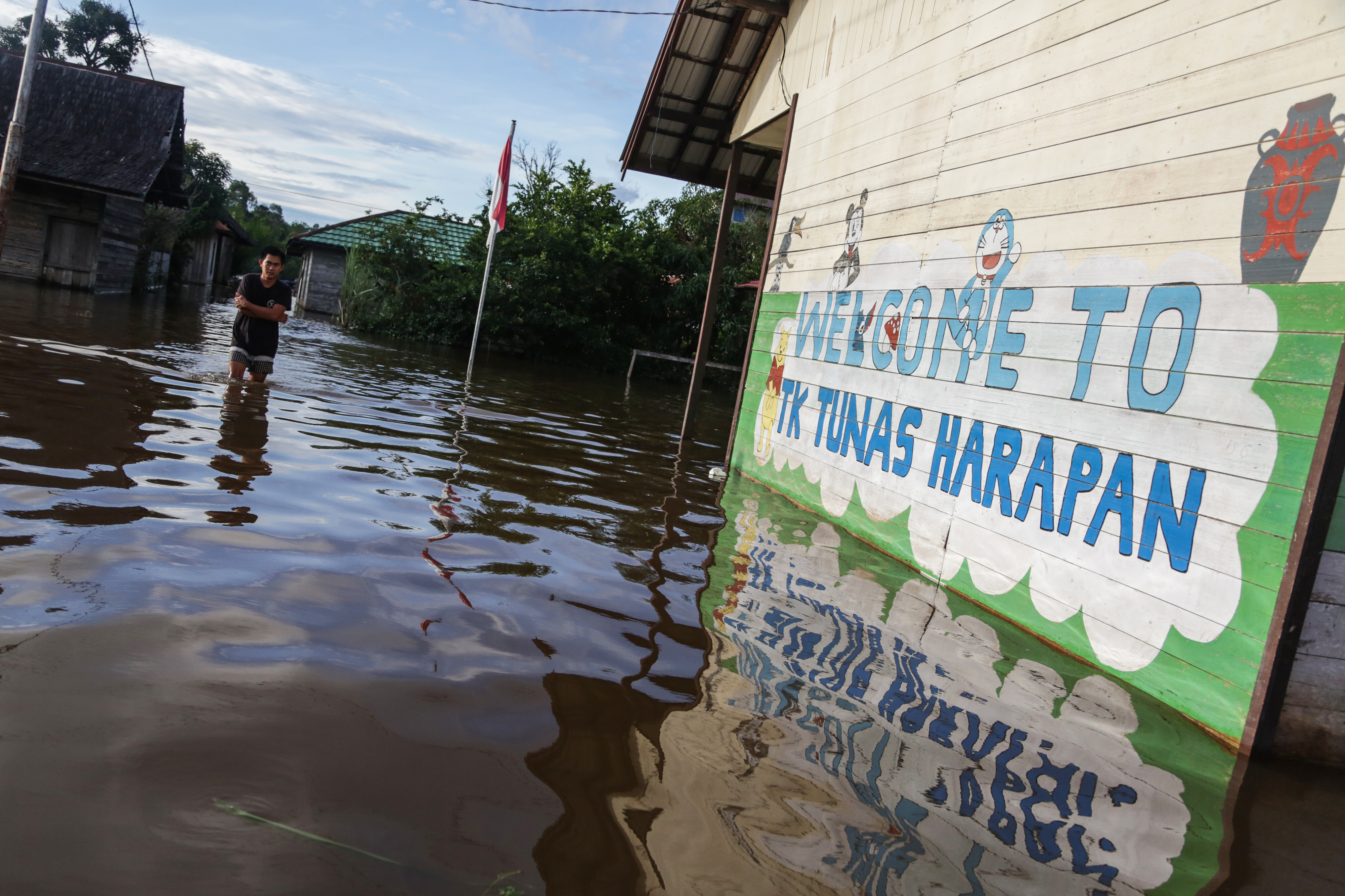 Warga menerobos banjir yang merendam permukiman sekitar rumahnya di Desa Petak Bahandang, Kabupaten Katingan, Kalimantan Tengah.
