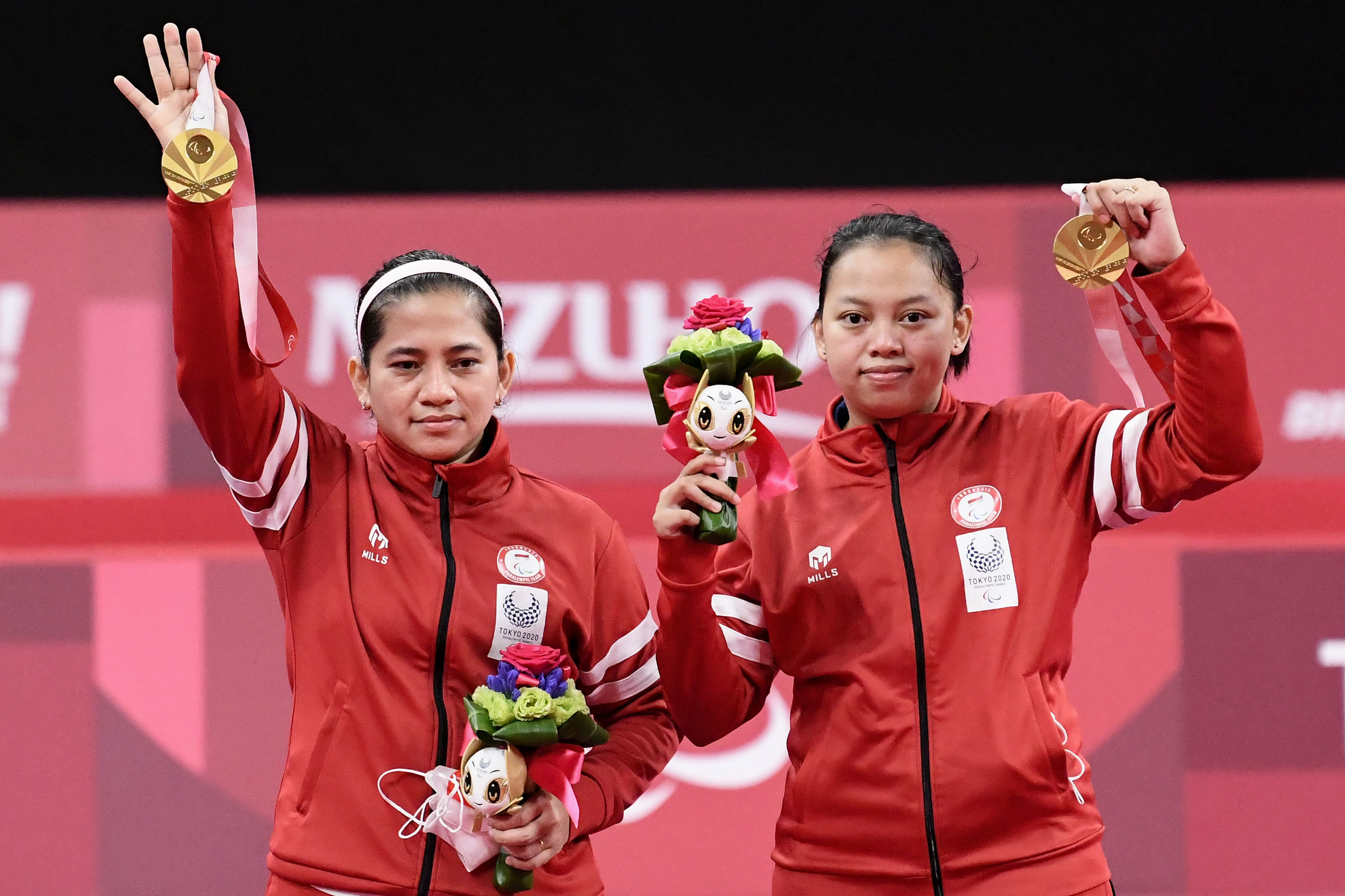 Pasangan bulu tangkis Oktila Leani Ratri dan Sadiyah Khalimatus berpose usai mendapat medali emas Paralimpiade Tokyo 2020