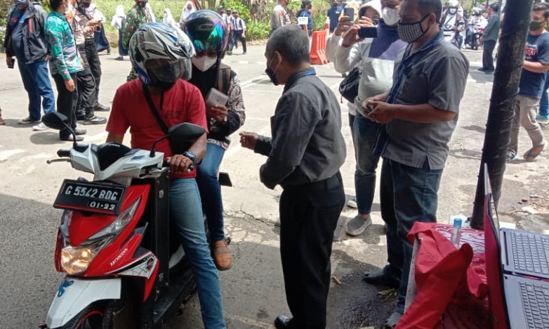 Petugas memeriksa surat vaksin warga yang akan masuk kompleks OW Guci di pintu gerbang. MI/Supardji Rasban