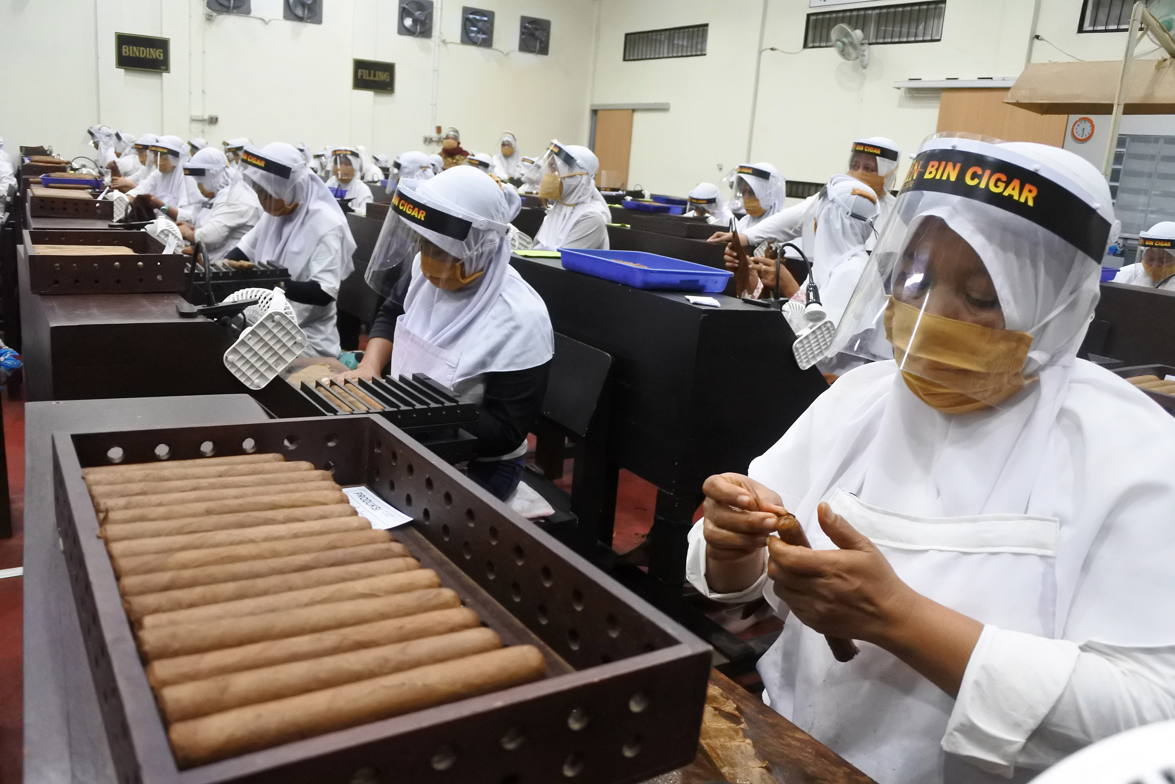 Ilustrasi pekerja membuat produk cerutu tembakau di pabrik wilayah Jember, Jawa Timur.