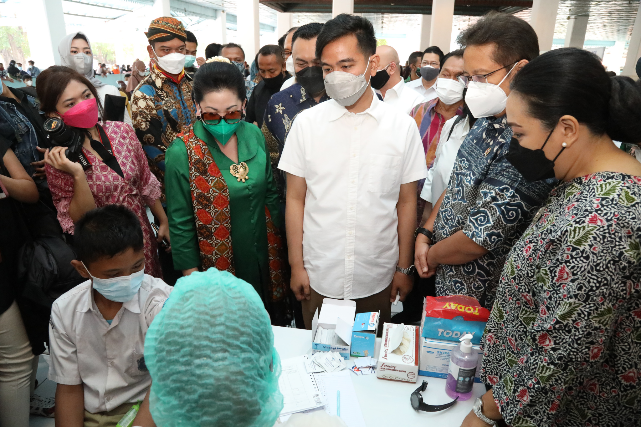 Menteri Kesehatan Budi Gunadi Sadikin dan Wali Kota Surakarta Gibran Rakabuming Raka melihat seorang warga tengah divaksinasi