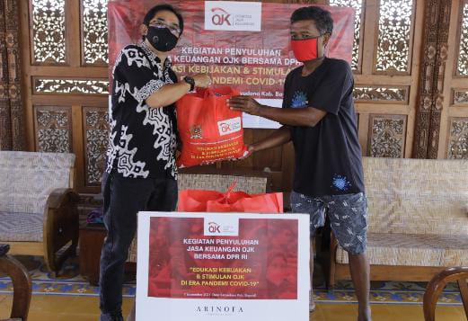 Seorang warga menerima bantuan sembako.