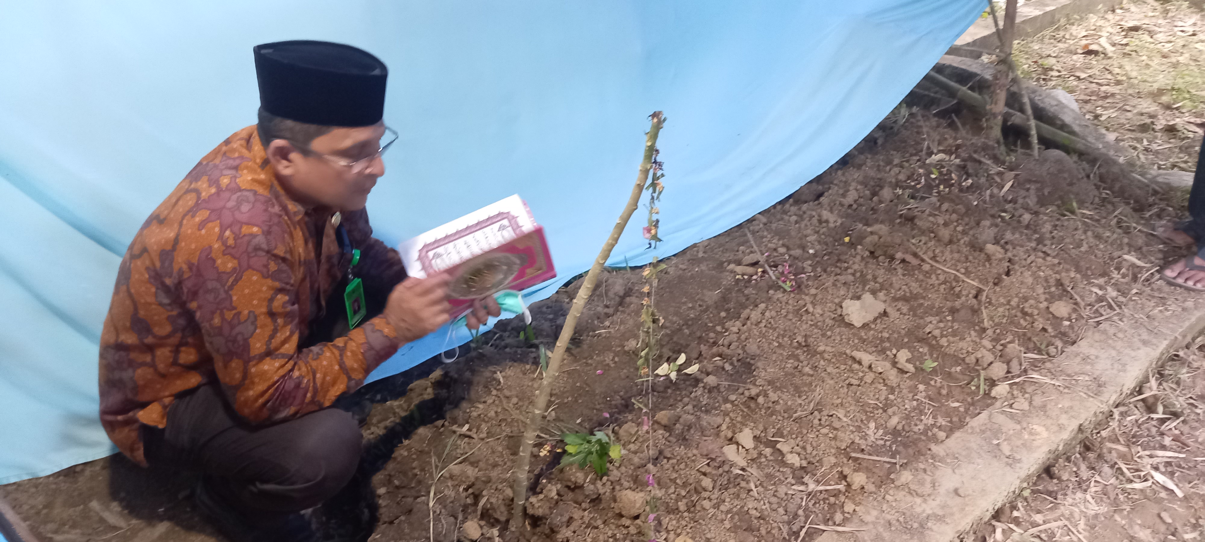 Kepala Kantor Kementerian Agama, Kabupaten Pidie, Abdullah AR, membaca Al-quran di makam Teungku Husin, pada Jumat (24/9).