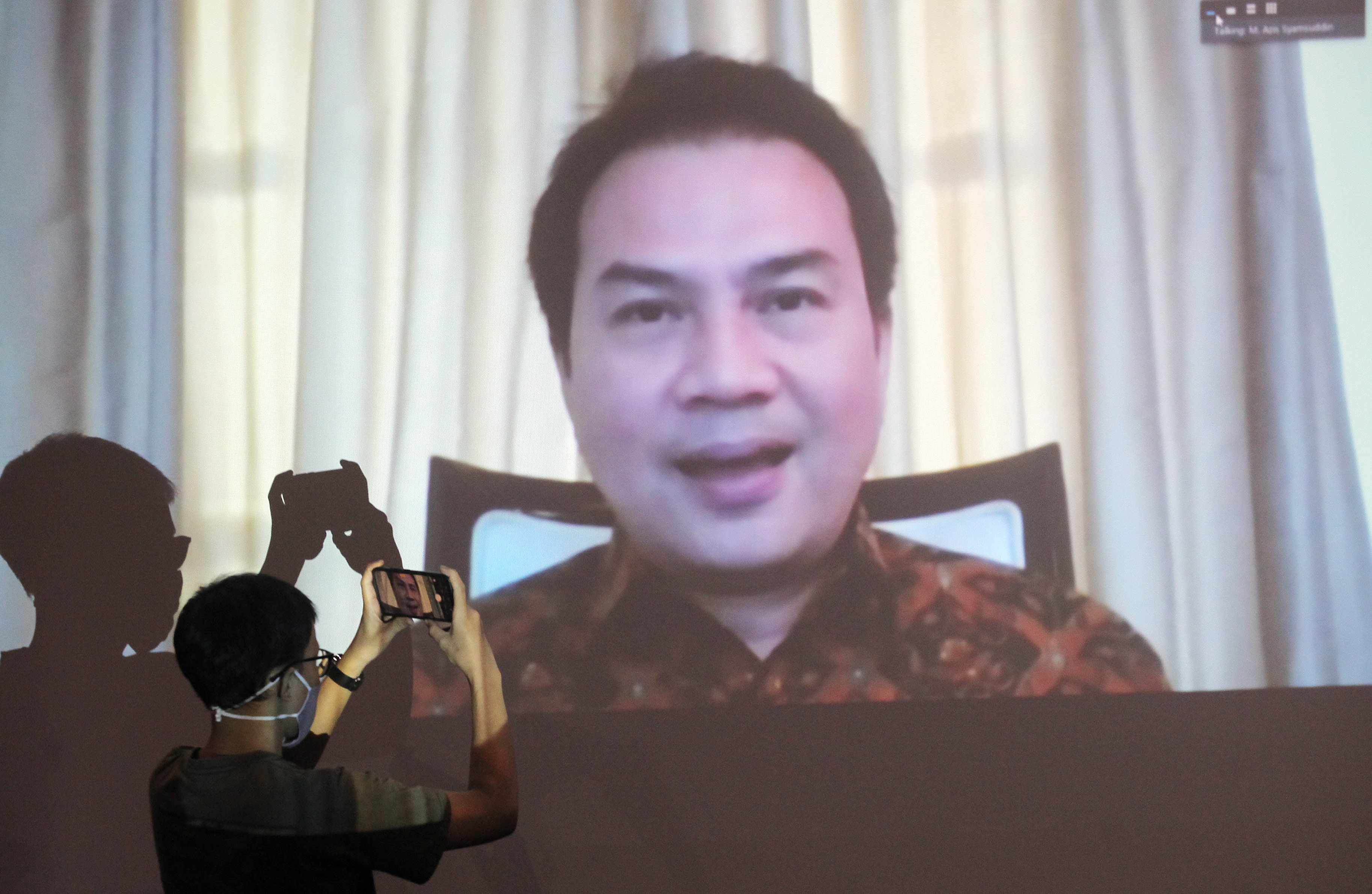 Jurnalis merekam layar monitor yang menampilkan Wakil Ketua DPR Azis Syamsuddin.