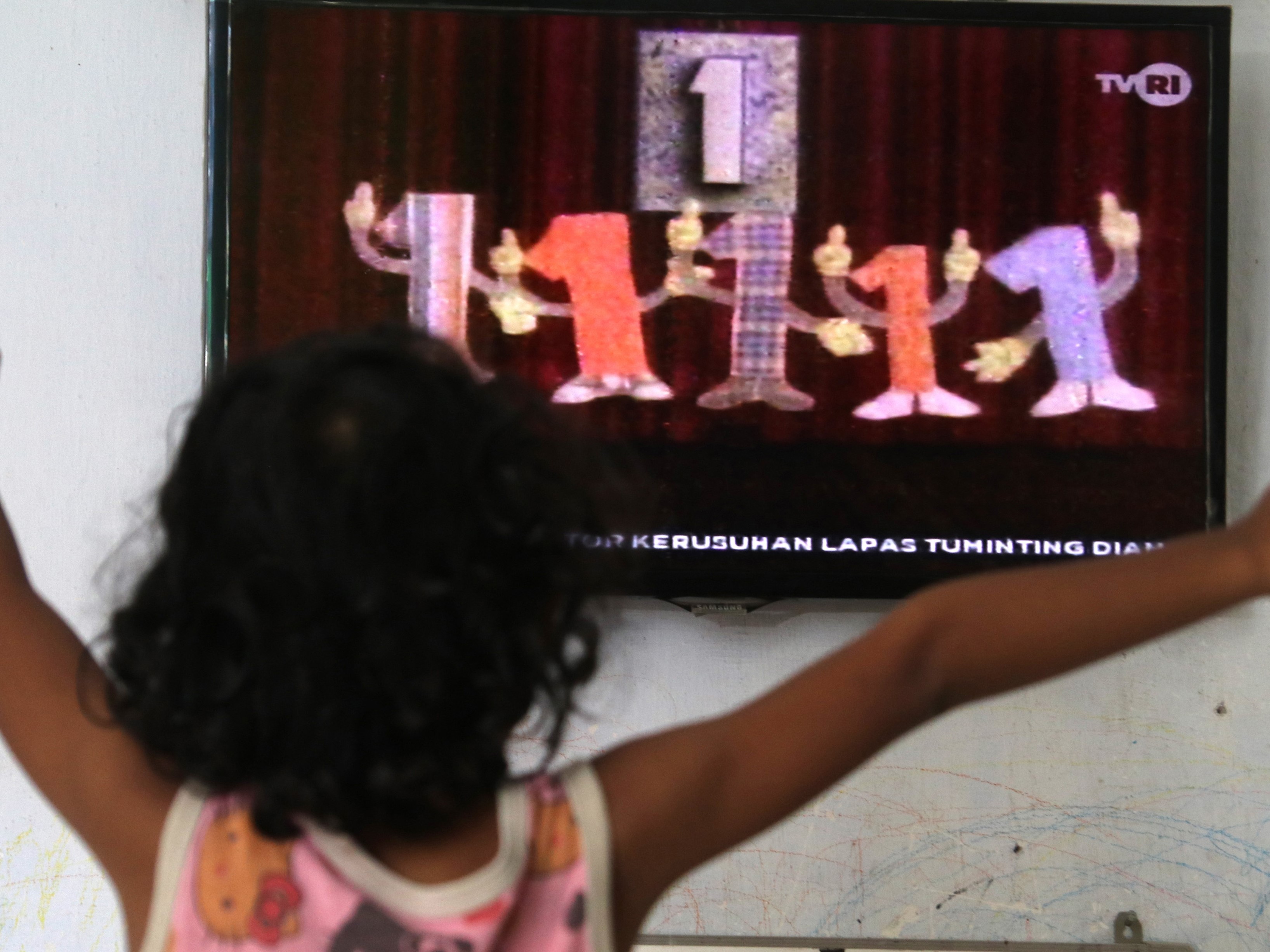 Seorang anak menonton televisi siaran perdana Belajar dari Rumah tingkat PAUD yang diselenggarakan Kementerian Pendidikan dan Kebudayaan.