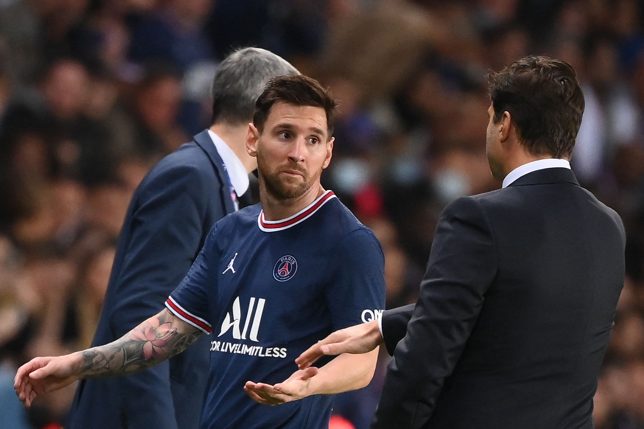 Pemain PSG Lionel Messi (kiri) melewati pelatih Mauricio Pochettino saat digantikan dalam laga Ligue 1 melawan Lyon.