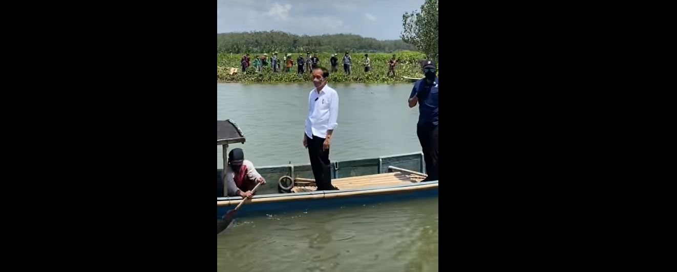 Jokowi didampingi Komandan Grup A Paspampres Anan Nurakhman menyeberangi sungai di Cilacap, Jawa Tengah.