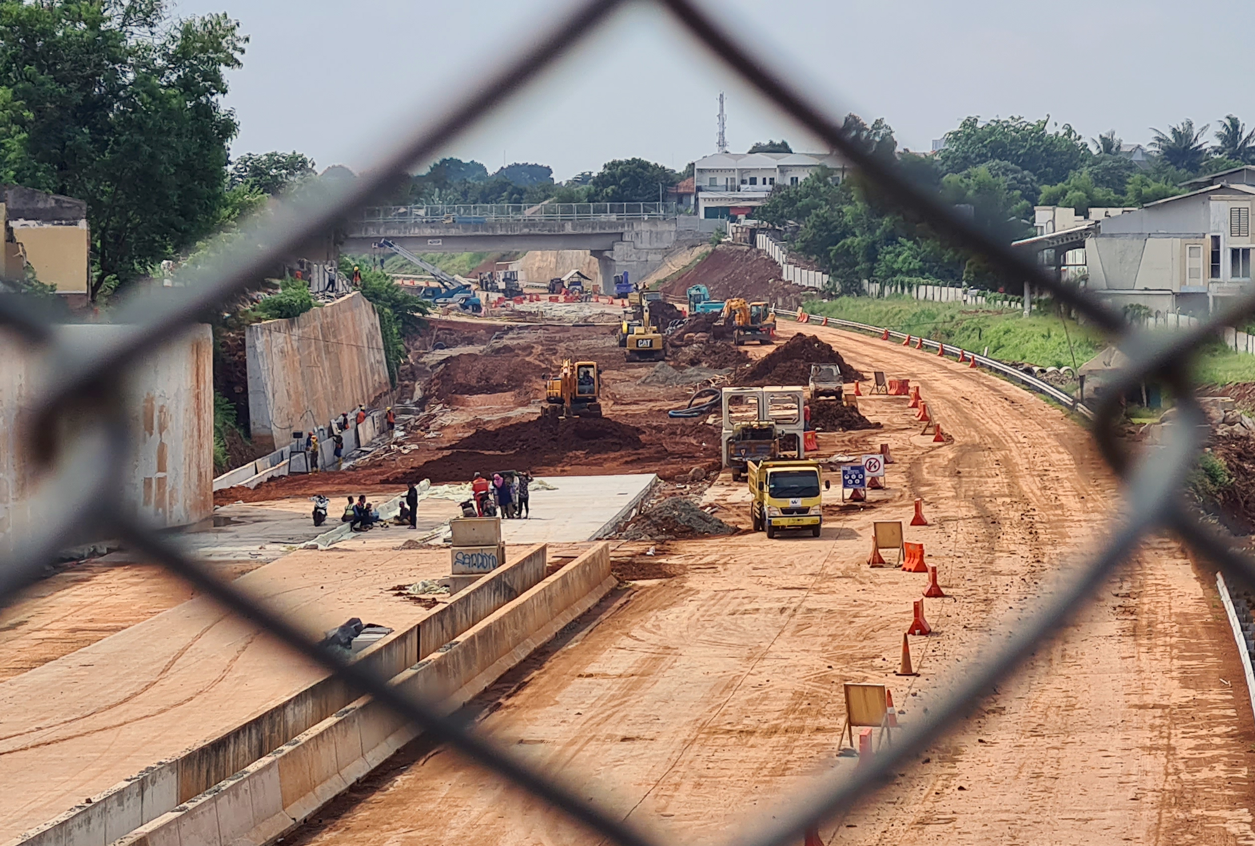 Ilustrasi pekerja dengan menggunakan alat berat menyelesaikan pembangunan jalan tol.