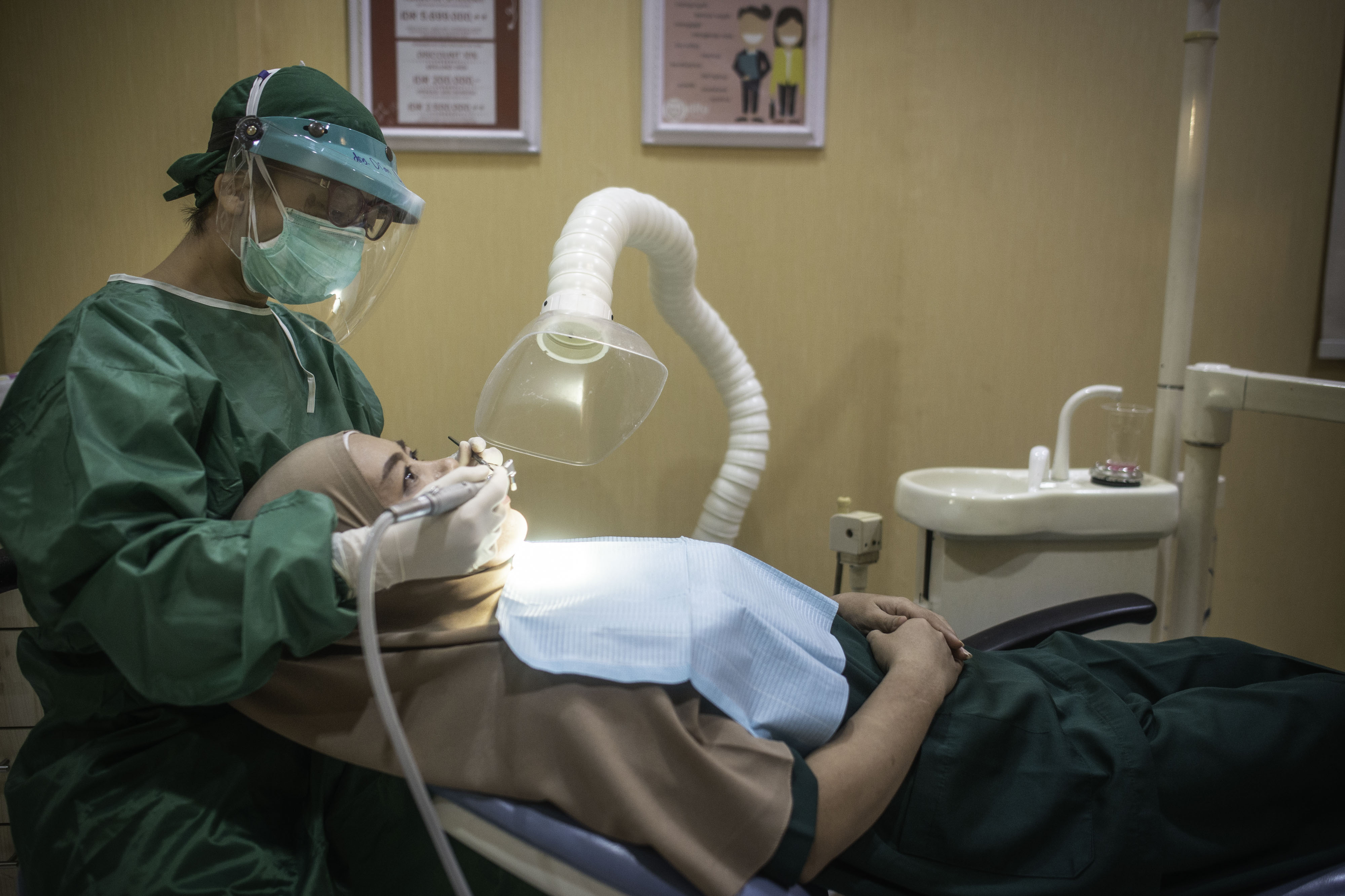 Seorang dokter gigi sedang menangani pasiennya.