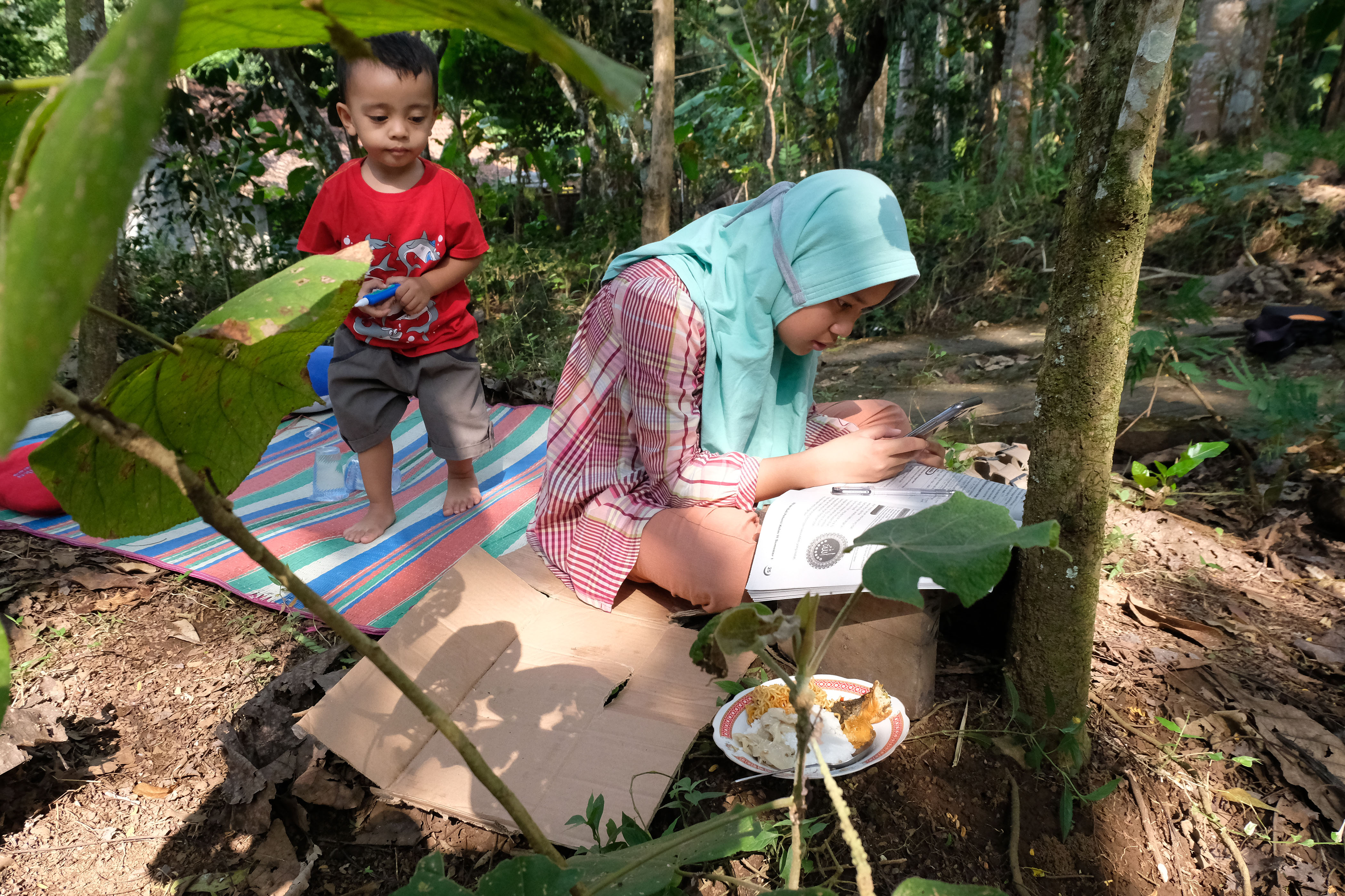 Sulit sinyal, siswa SD Nadhifa Muazara mengerjakan tugas daring di perkebunan di Dusun Pandansari, Salaman, Magelang, Sabtu (18/9/2021). 