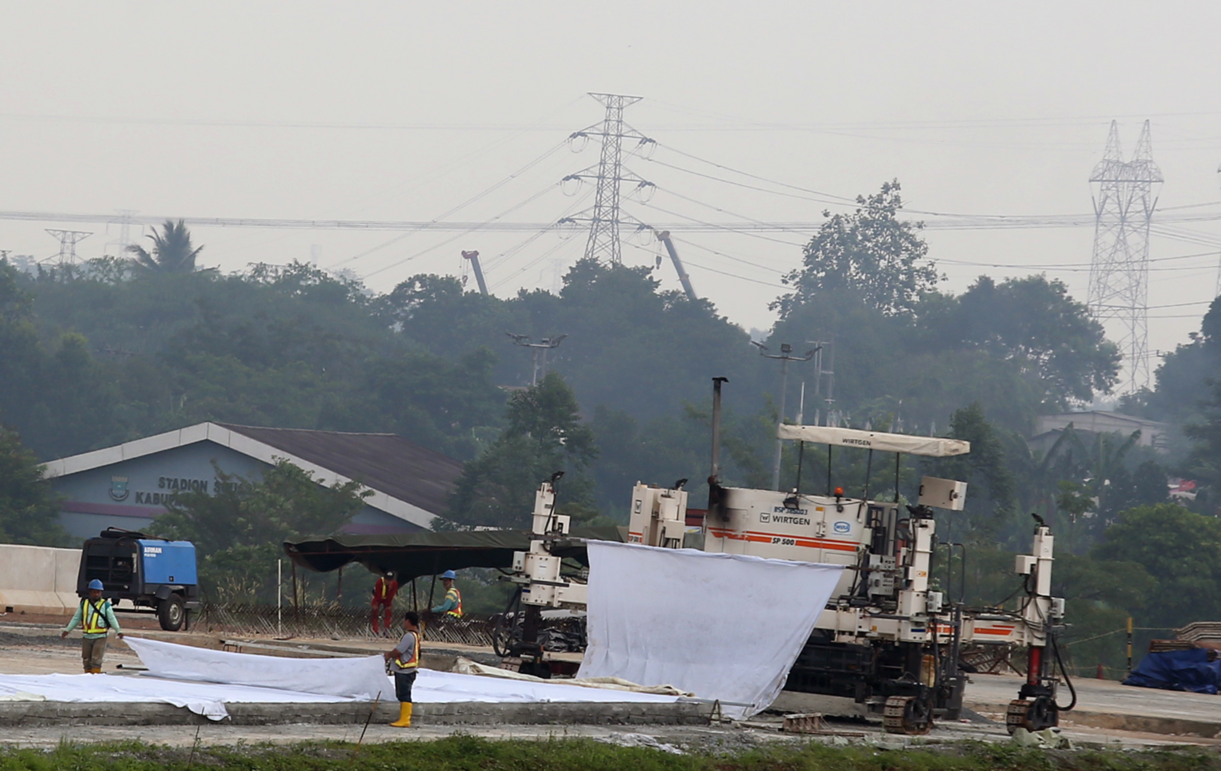 Pekerja menyelesaikan pembangunan jalan Tol Serpong Balaraja (Serbaraja) seksi pertama di Kawasan Serpong, Tangerang, Selasa (24/8/2021)