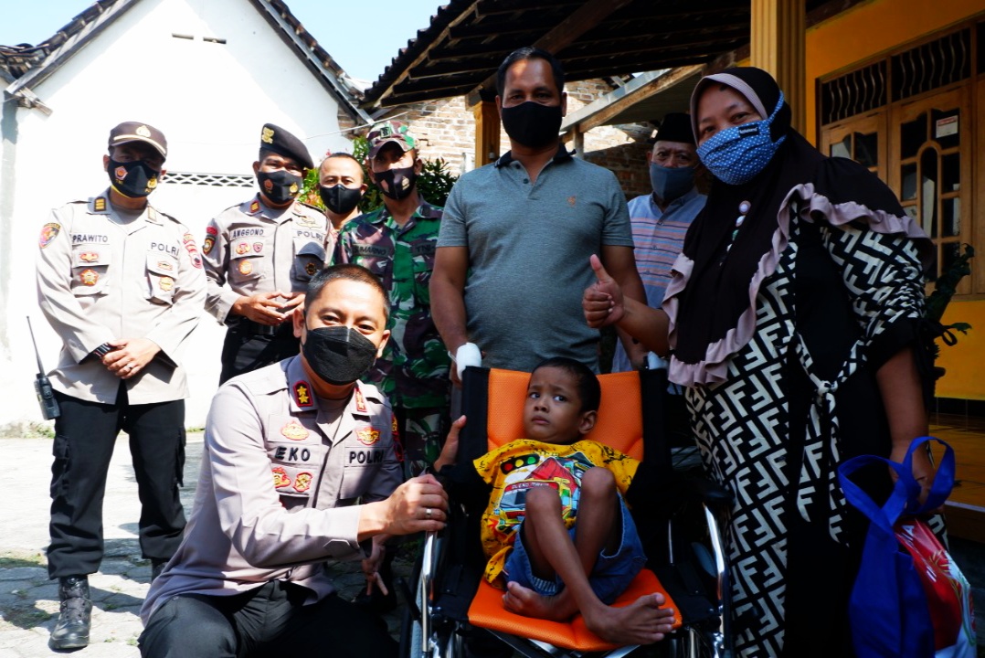apolres Klaten AKB Eko Prasetyo (jongkok) seusai menyerahkan kursi roda untuk Arya Bima.
