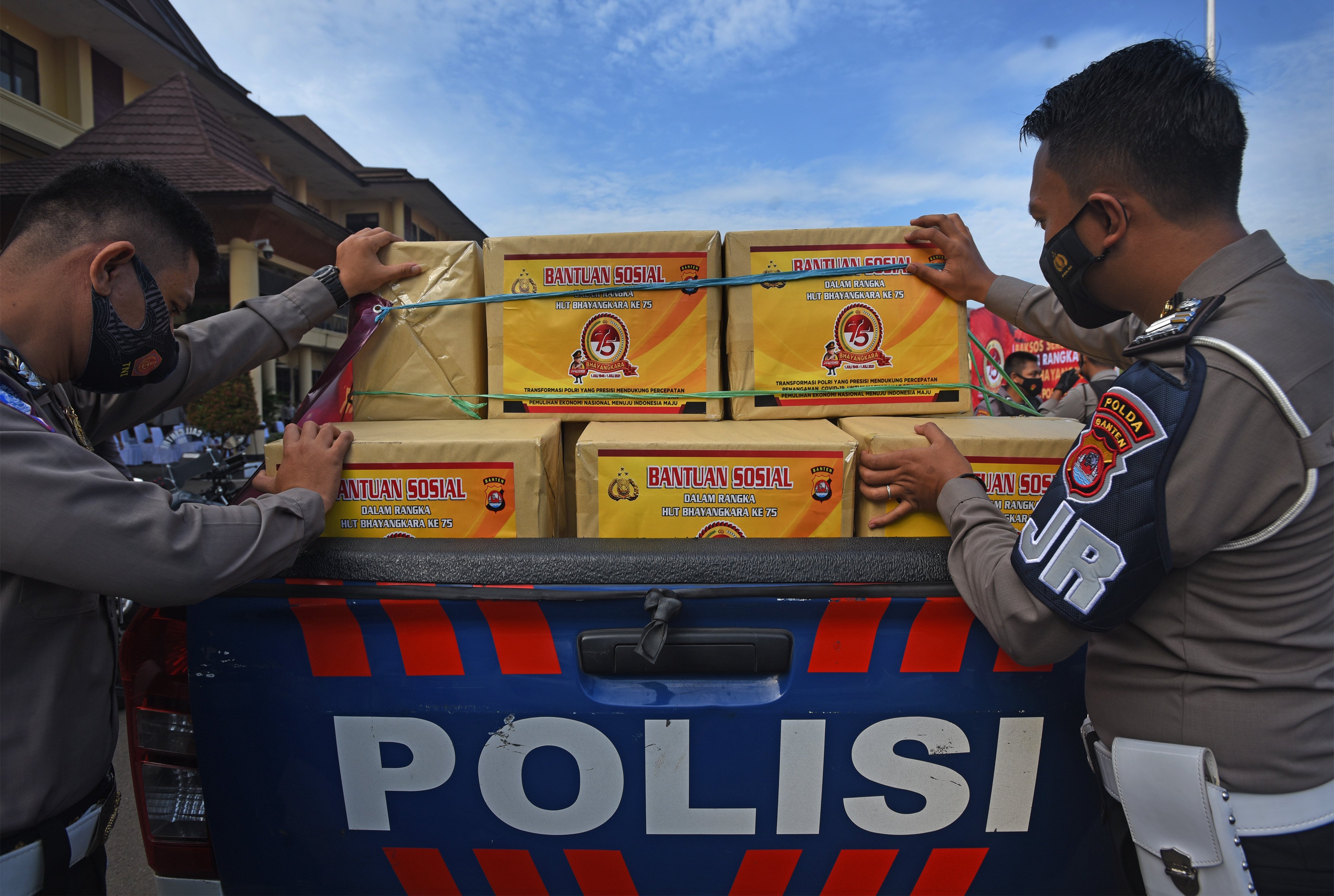 Dua anggota polisi menyiapkan paket bantuan sembako untuk warga terdampak pandemi covid di Mapolda Banten, Serang, Banten.