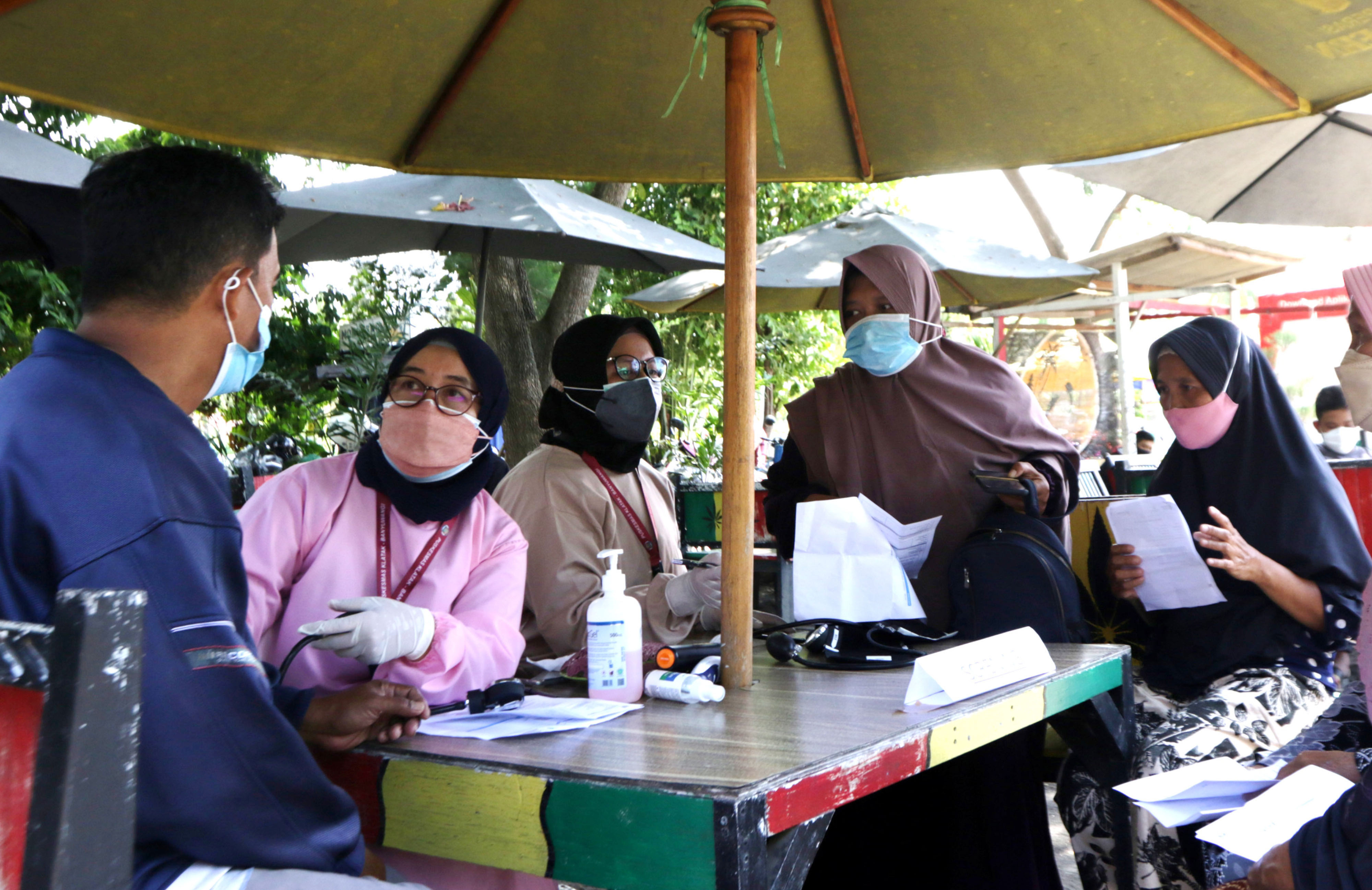 Tenaga medis memeriksa kesehatan pengunjung yang akan menerima vaksin covid-19 di Pantai Cacalan, Banyuwangi, Jawa Timur, Sabtu (25/9/2021).