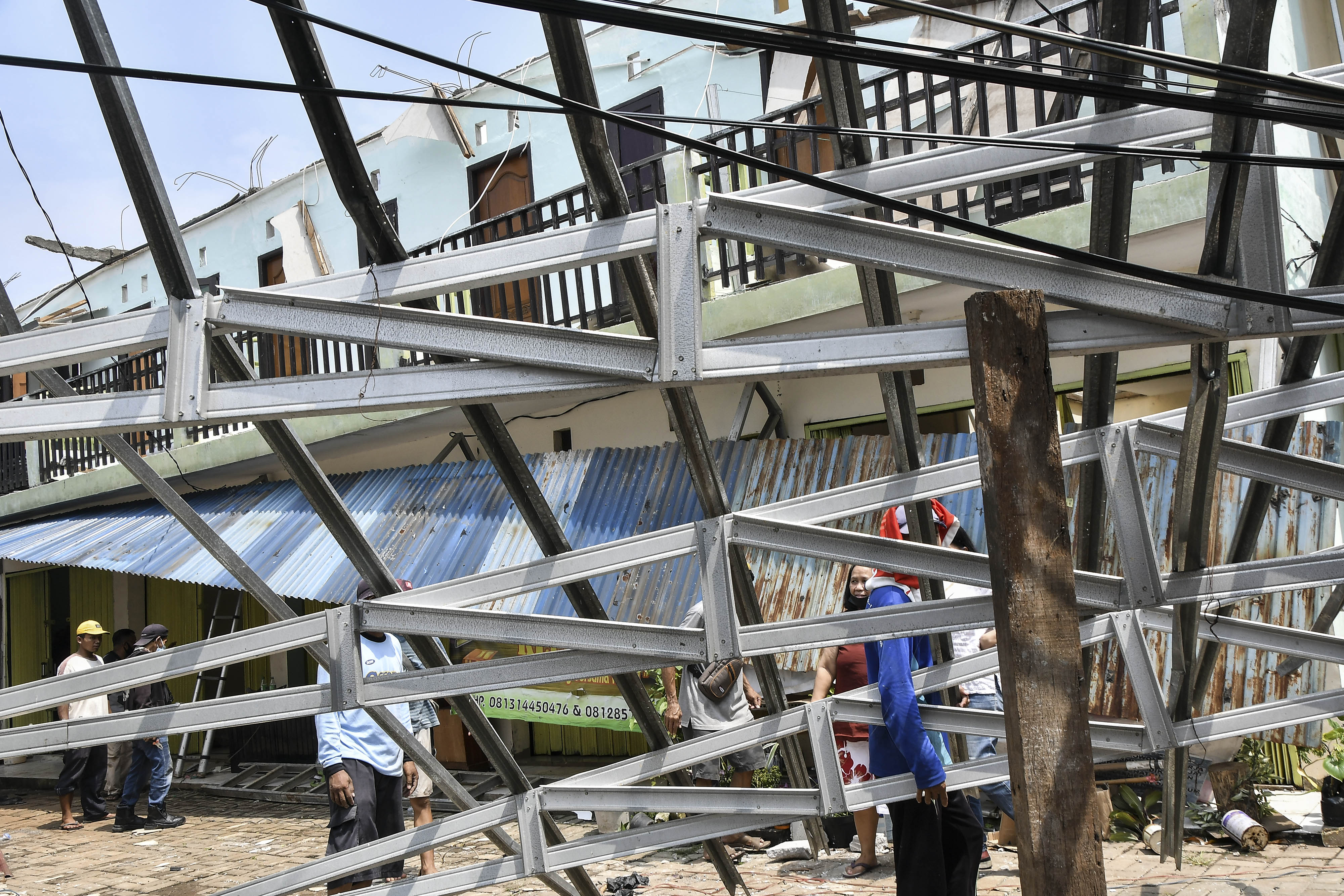 Ilustrasi warga yang memperbaiki atap rumah yang rusak akibat diterjang puting beliung.