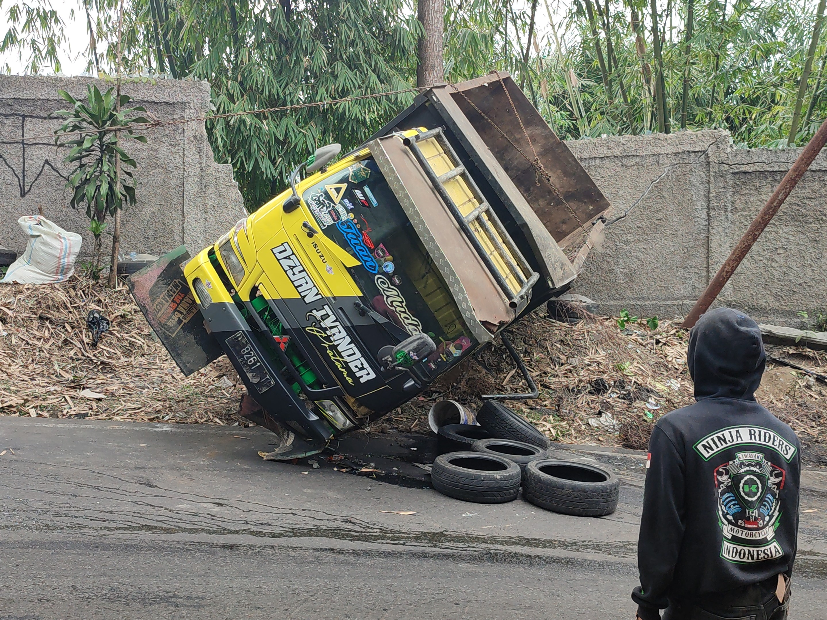 Truk sampah yang terguling.