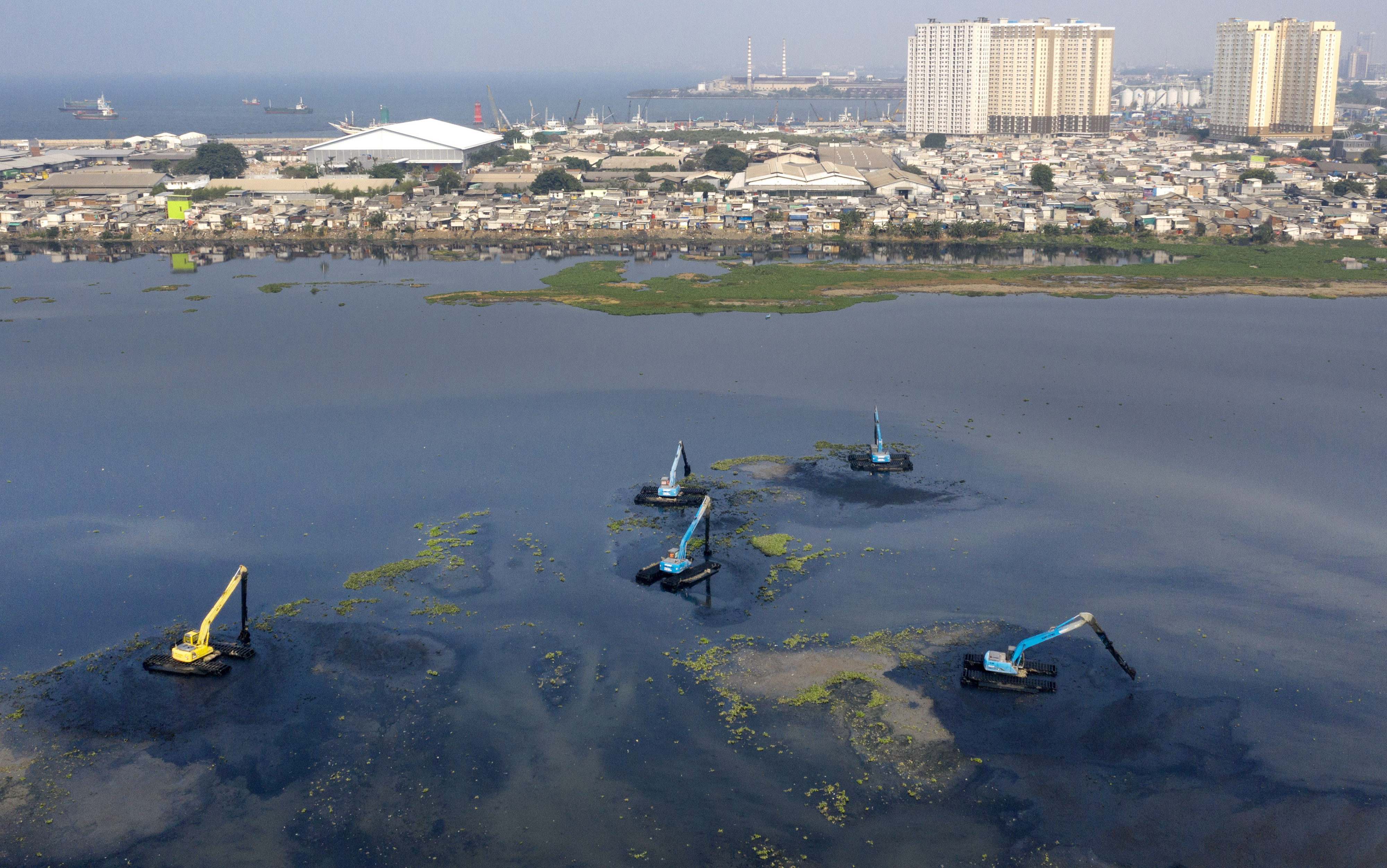  Pekerja menggunakan alat berat untuk mengeruk Waduk Pluit di Jakarta, Senin (11/11/2019)