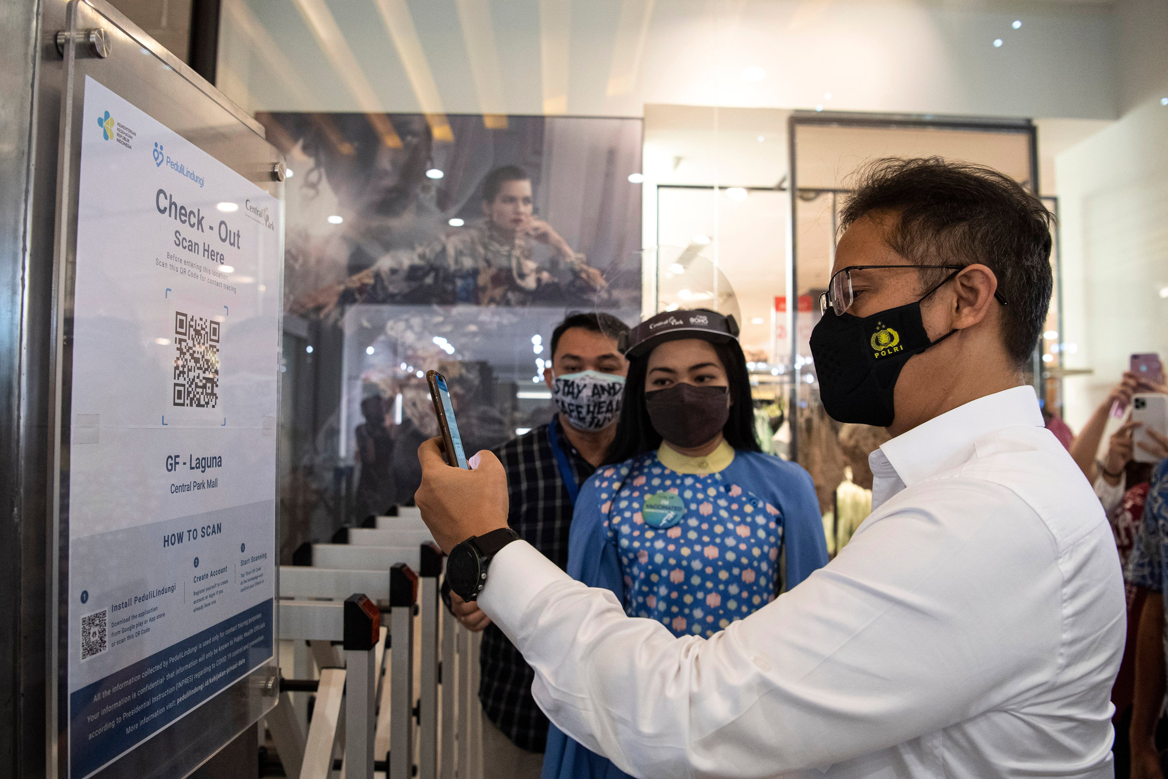 Menkes Budi Gunadi Sadikin (kanan) melakukan scan barcode melalui aplikasi PeduliLindungi.