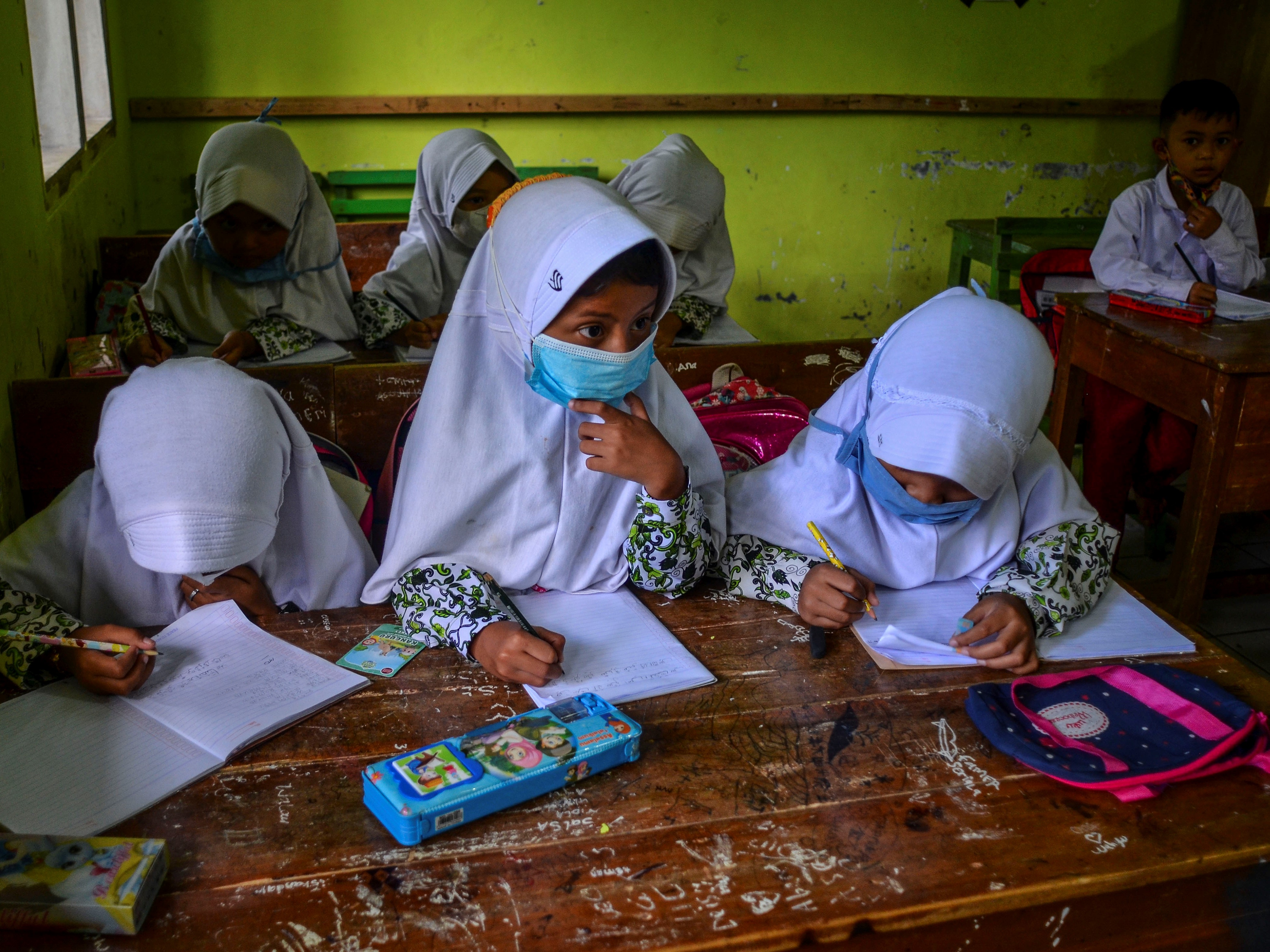 Siswa kelas I dan II mengikuti PTM terbatas dalam satu ruang kelas di Madrasah Ibtidaiyah Pasawahan, Dusun Ciakar, Kabupaten Ciamis, Jabar.