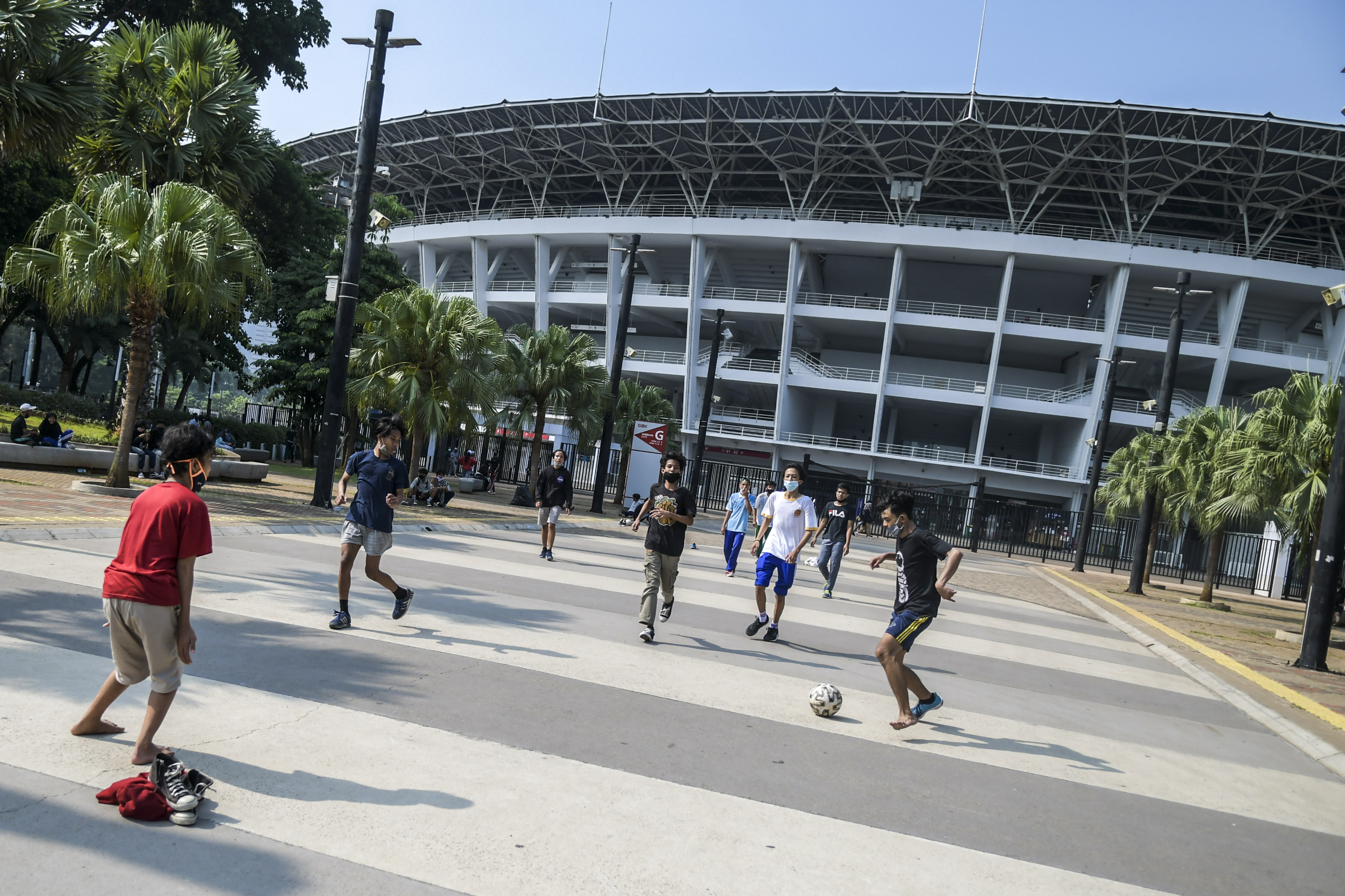 Warga bermain sepak bola di kawasan Stadion Utama Gelora Bung Karno (SUGBK) di Senayan, Jakarta.