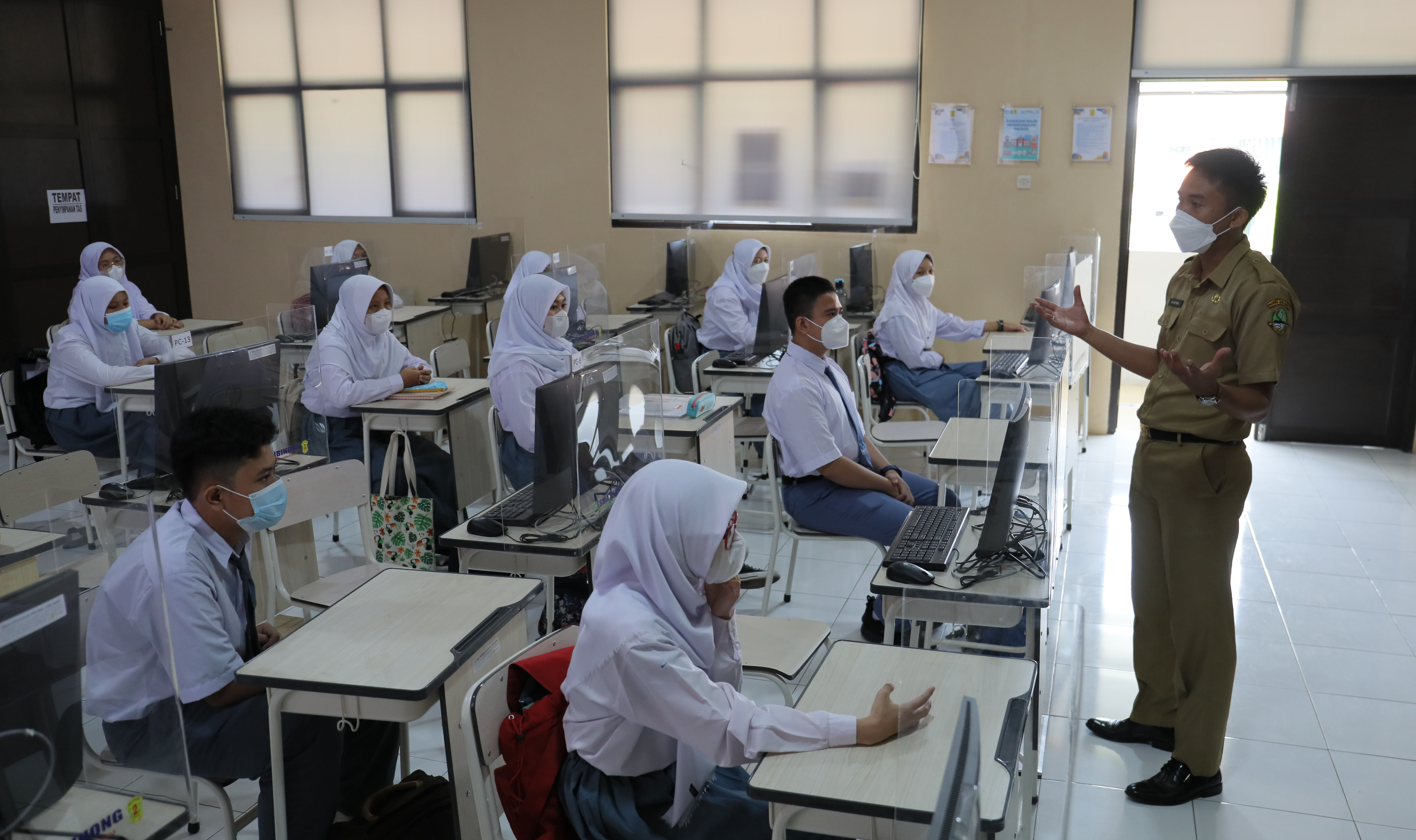 Siswa kelas 10 mengikuti pembelajaran tatap muka dalam kelas yang sudah dipasang penyekat di SMAN 2 Cibinong, Bogor, Jawa Barat.