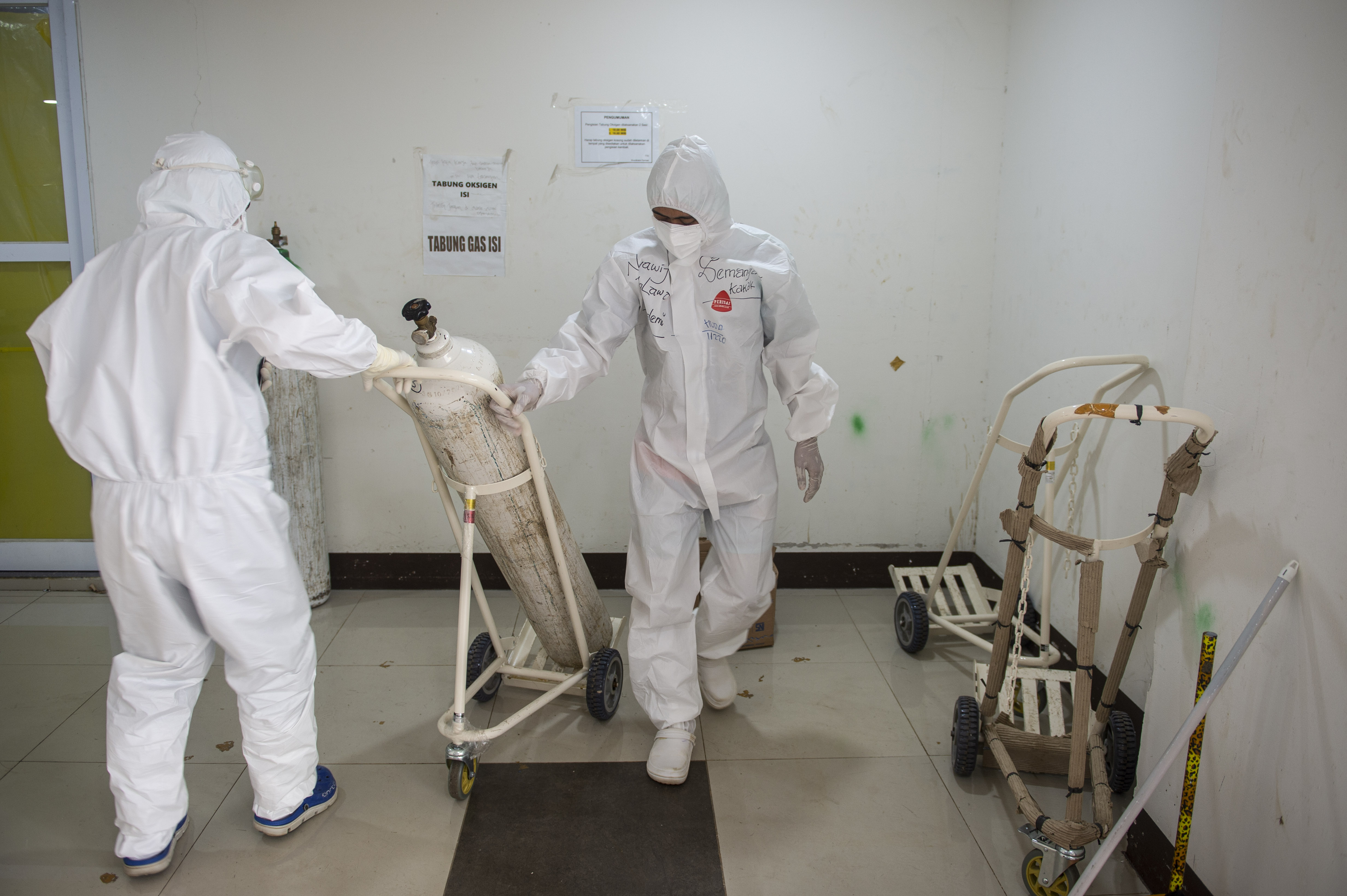 Tenaga kesehatan mendorong tabung oksigen di RSDC Wisma Atlet