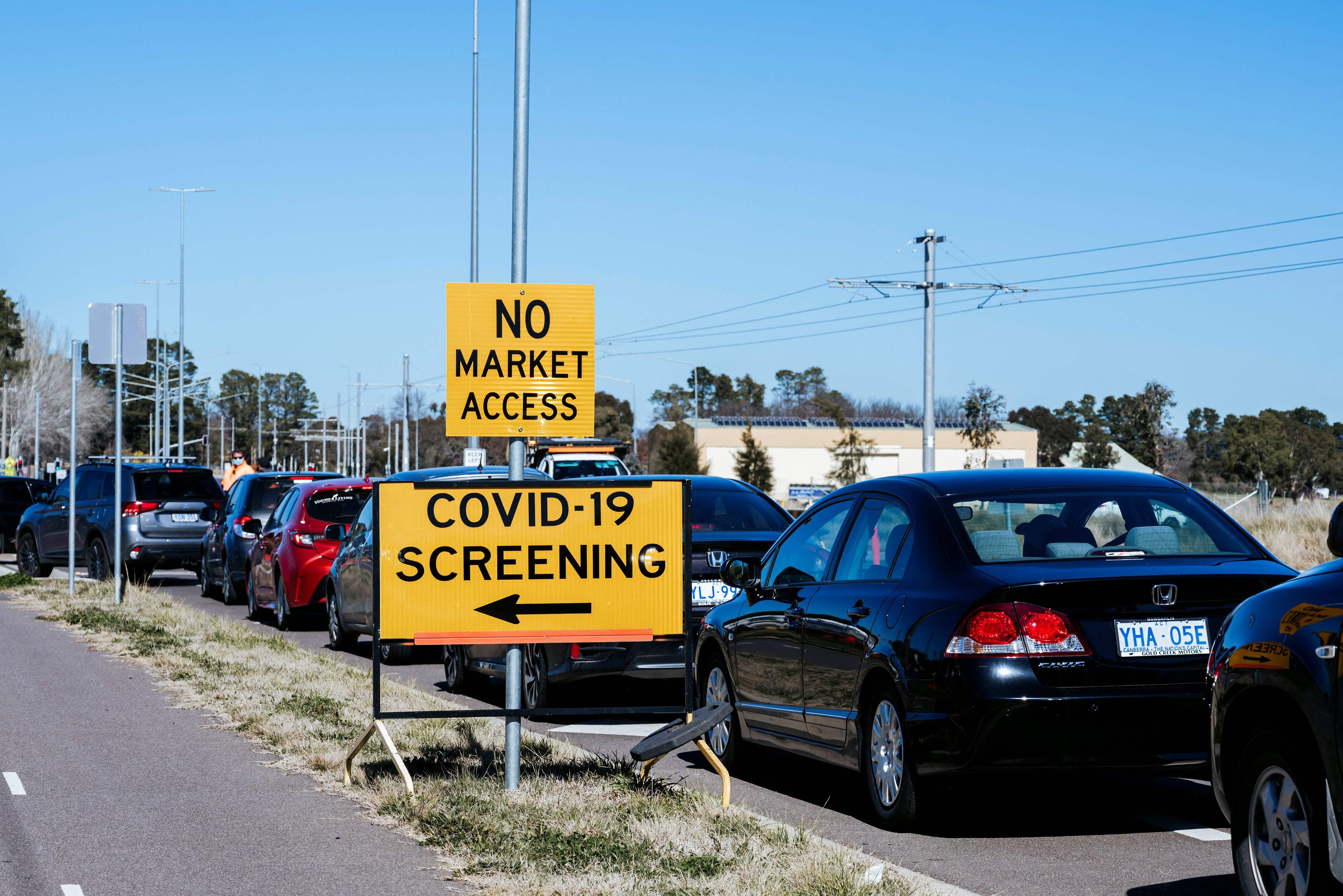 Warga mengantre di luar pusat pemeriksaan Covid-19 di Canberra selama lokcdown.