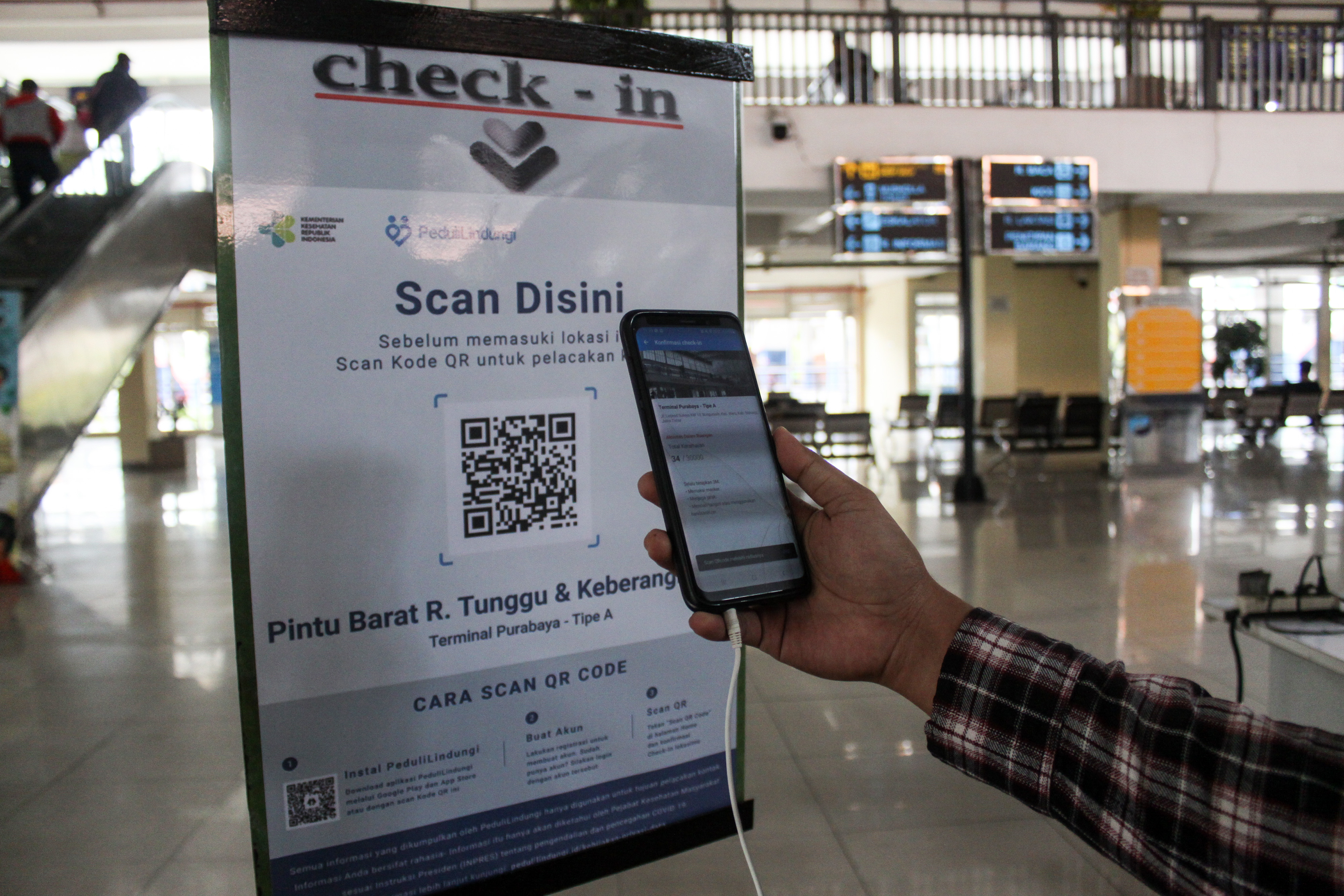 Calon penumpang melakukan scan melalui aplikasi PeduliLindungi di Terminal Purabaya, Bungurasih, Sidoarjo, Jawa Timur, Sabtu (11/9/2021)