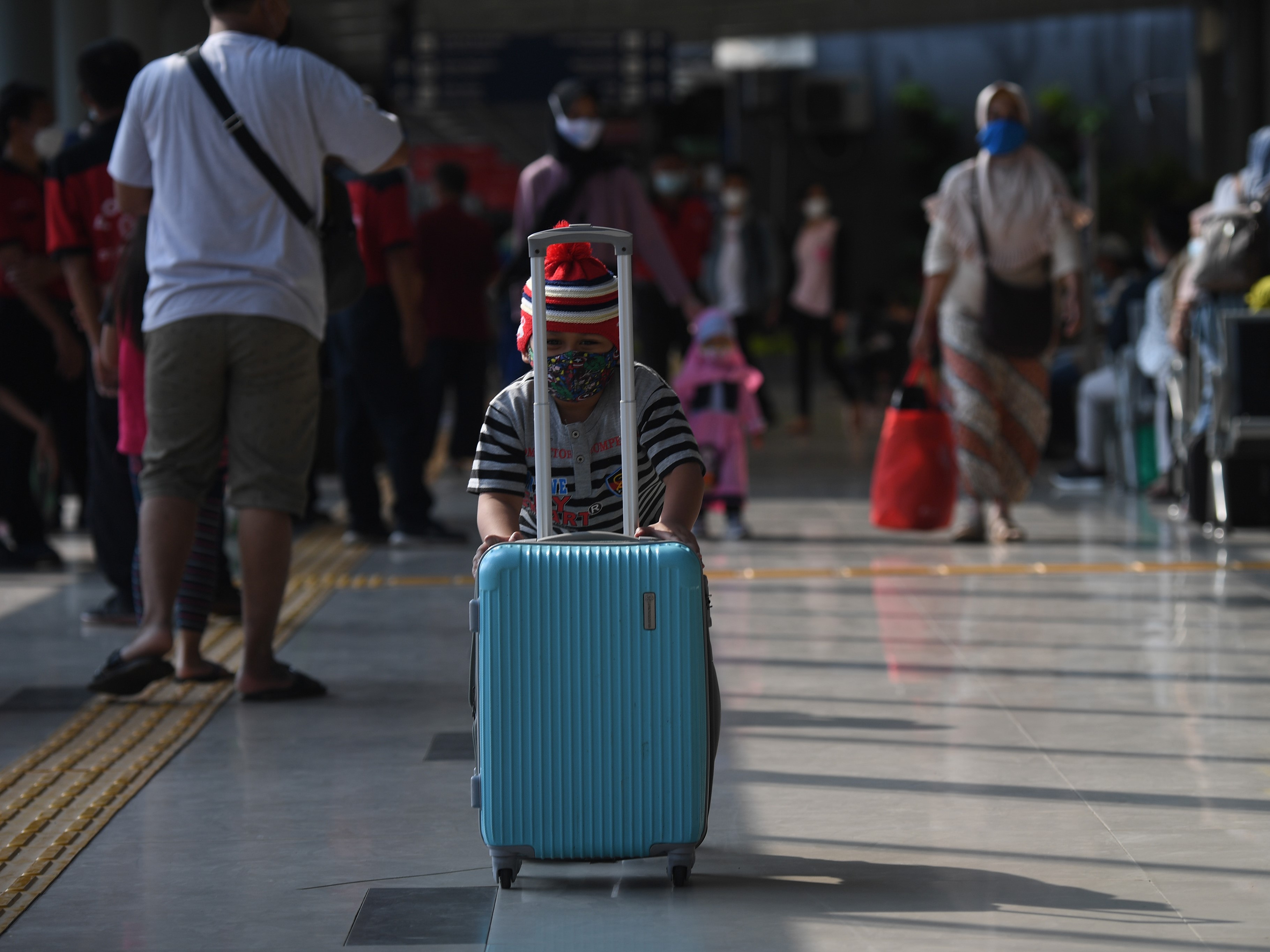 Seorang anak mendorong koper di ruang tunggu Stasiun Pasar Senen, Jakarta.
