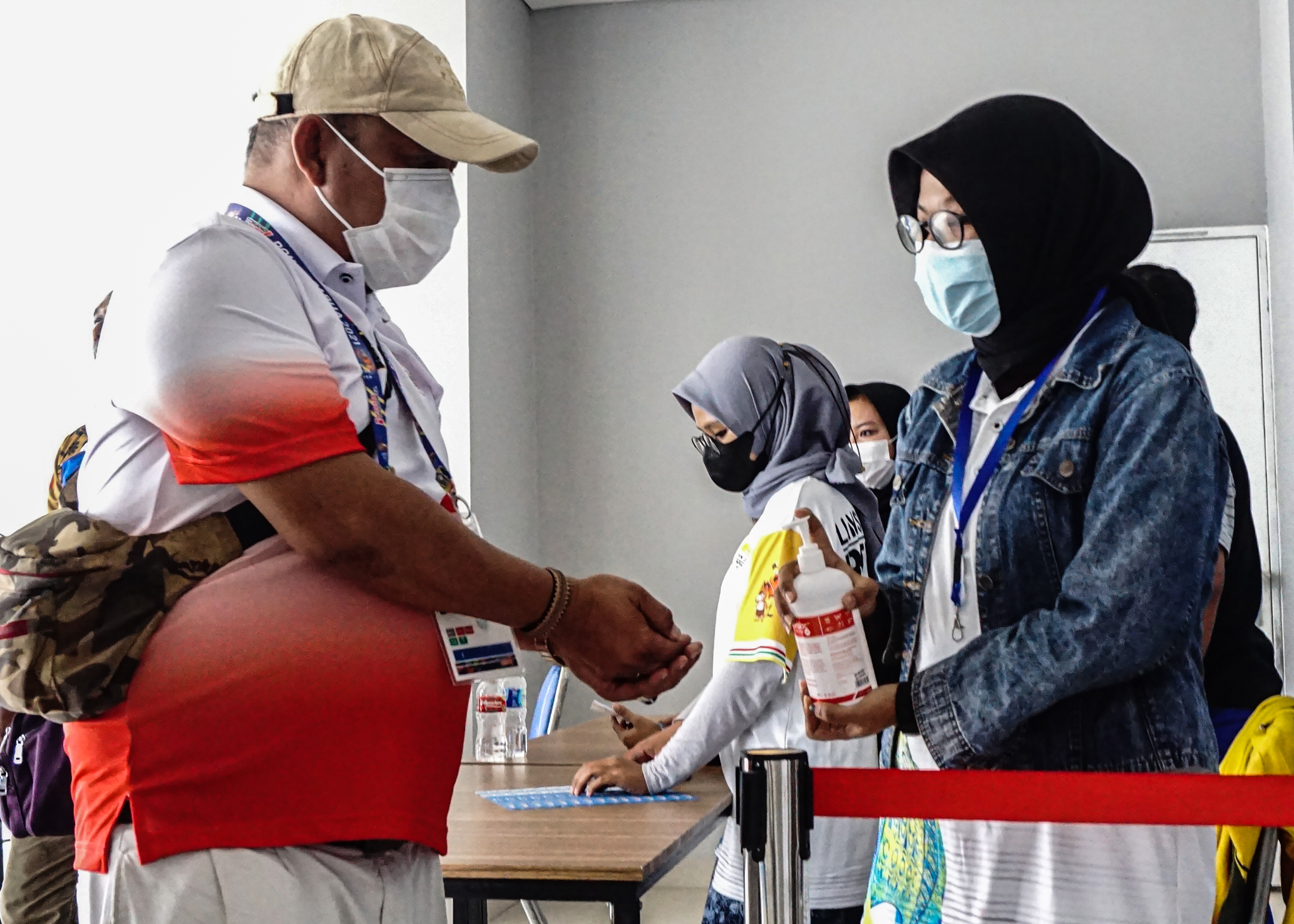 Petugas menyemprotkan cairan disinfektan ke pengunjung venue PON Papua