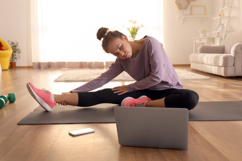 Seorang perempuan tengah berolahraga di rumah.