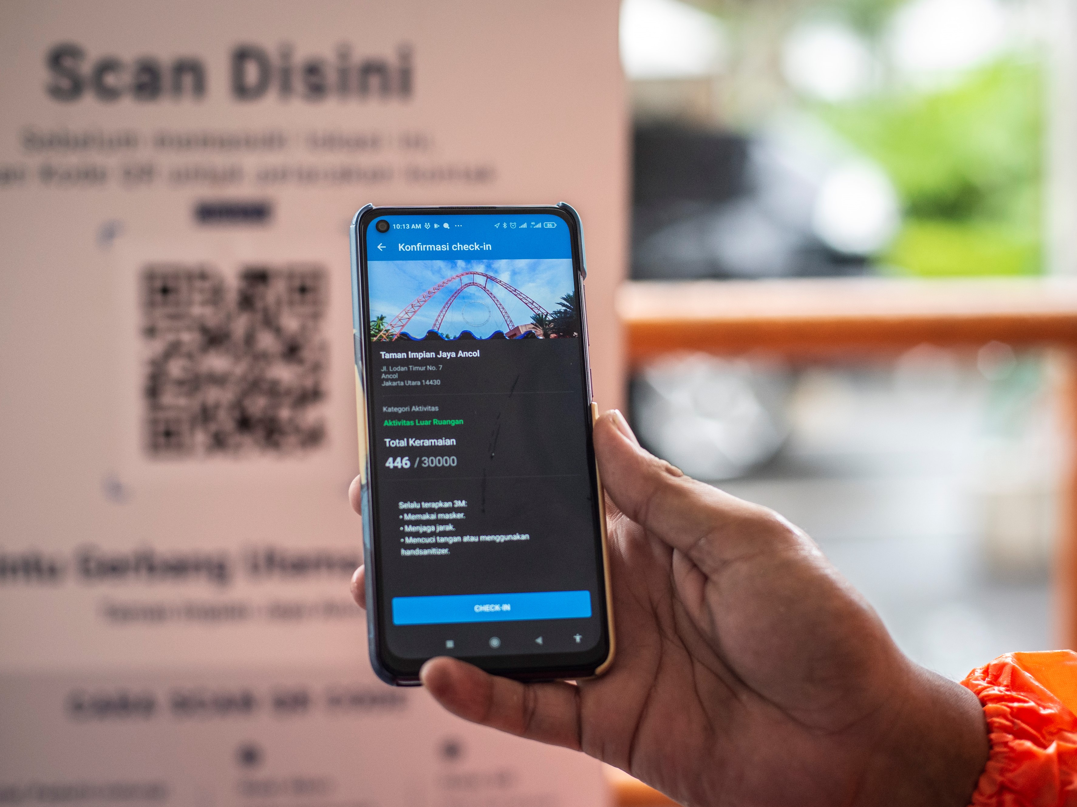 Pengunjung memindai kode batang (QR Code) melalui aplikasi PeduliLindungi di Pintu Gerbang Utama Timur, Taman Impian Jaya Ancol, Jakarta.