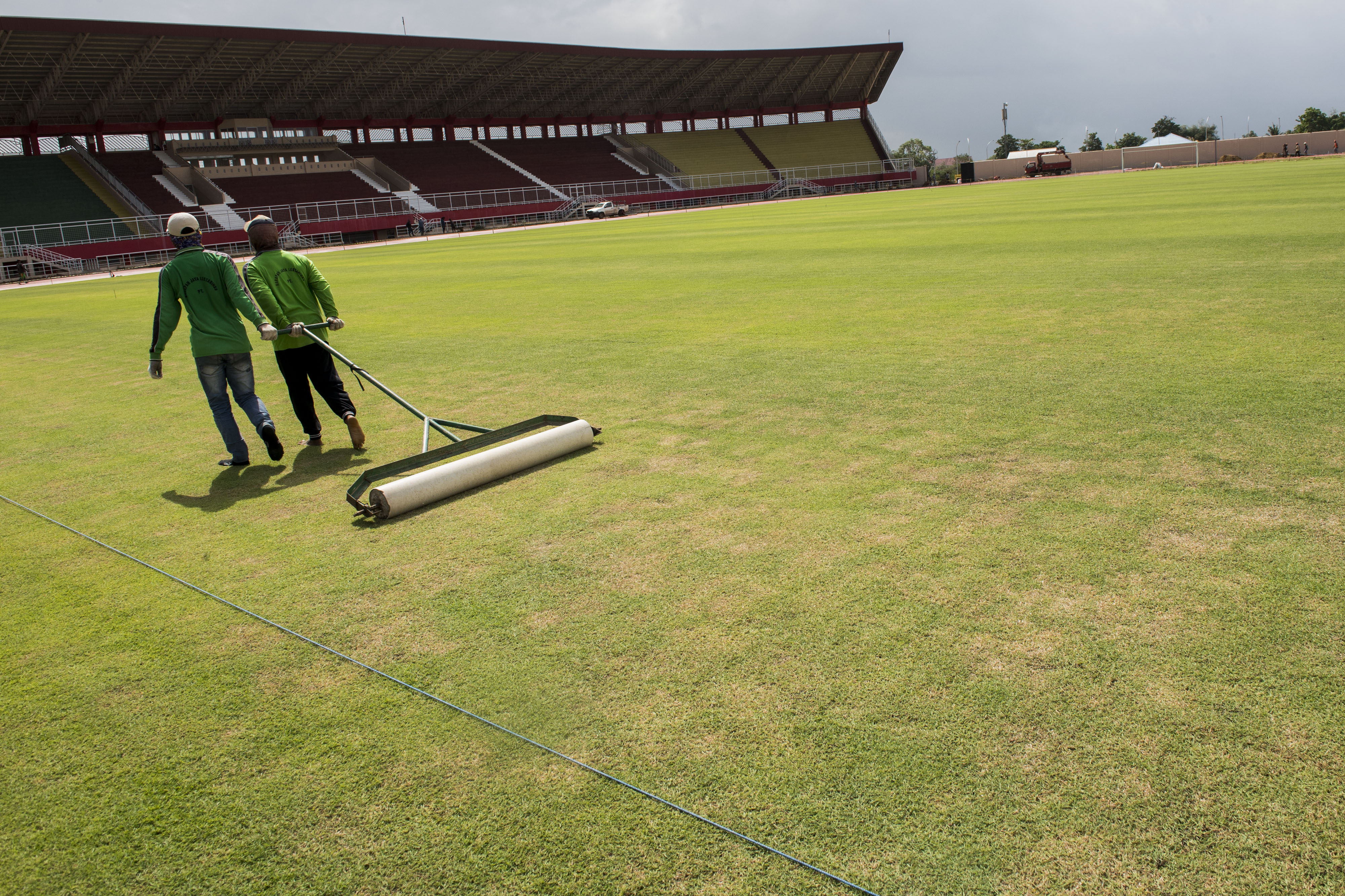 Pekerja melakukan perawatan rumput jelang pelaksanaan PON Papua XX di Stadion Katalpal.