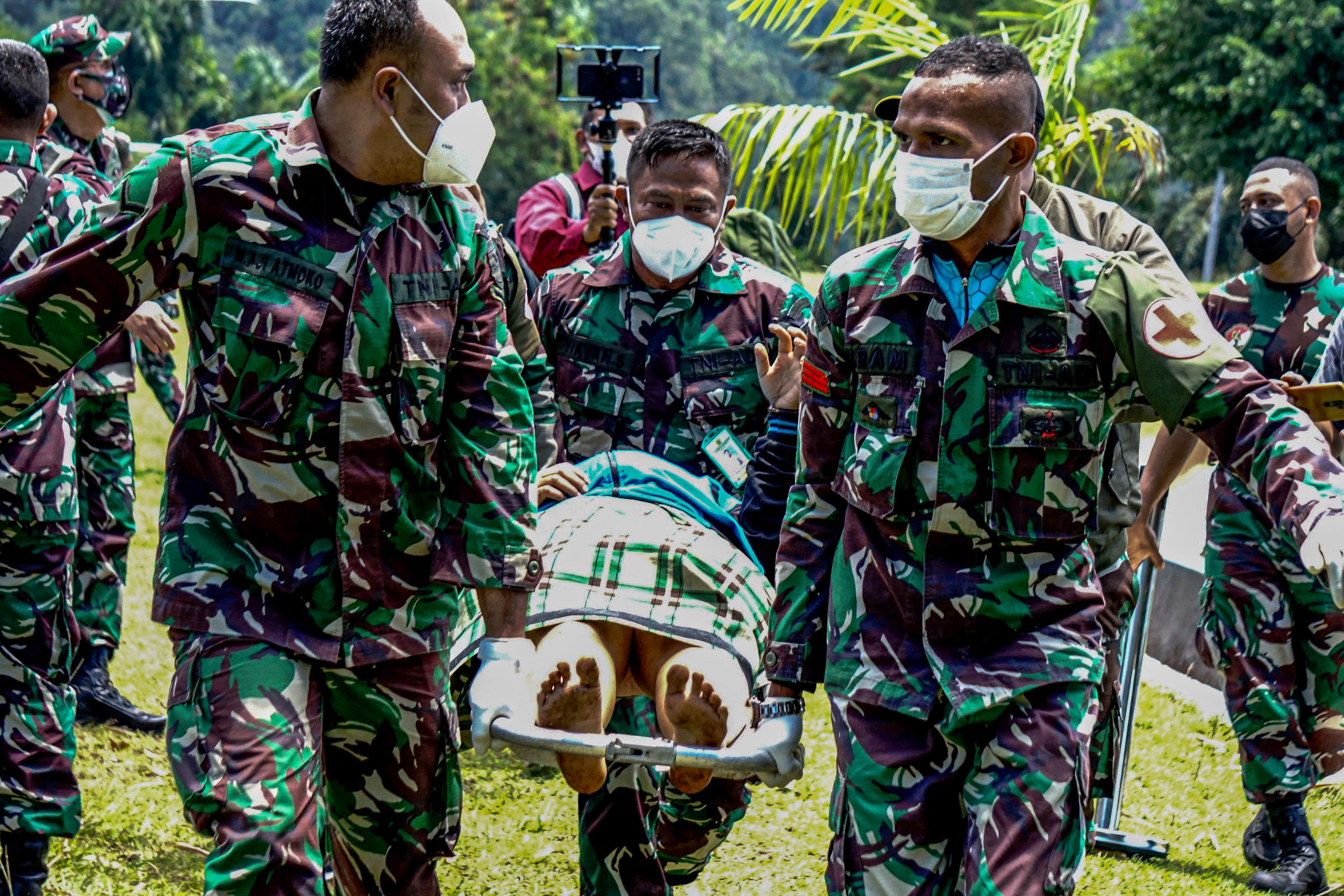 Prajurit TNI AD menggotong tenaga kesehatan (Nakes) korban penyerangan Kelompok Kriminal Bersenjata (KKB) di Papua.