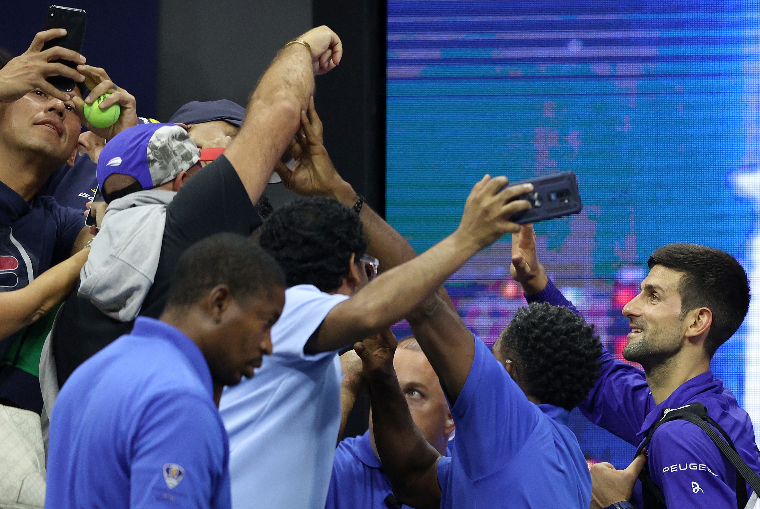 Para fans mengerumuni Novak Djokovic dari Serbia setelah mengalahkan petenis Italia Matteo Berrettini di laga perempat final AS Terbuka. 