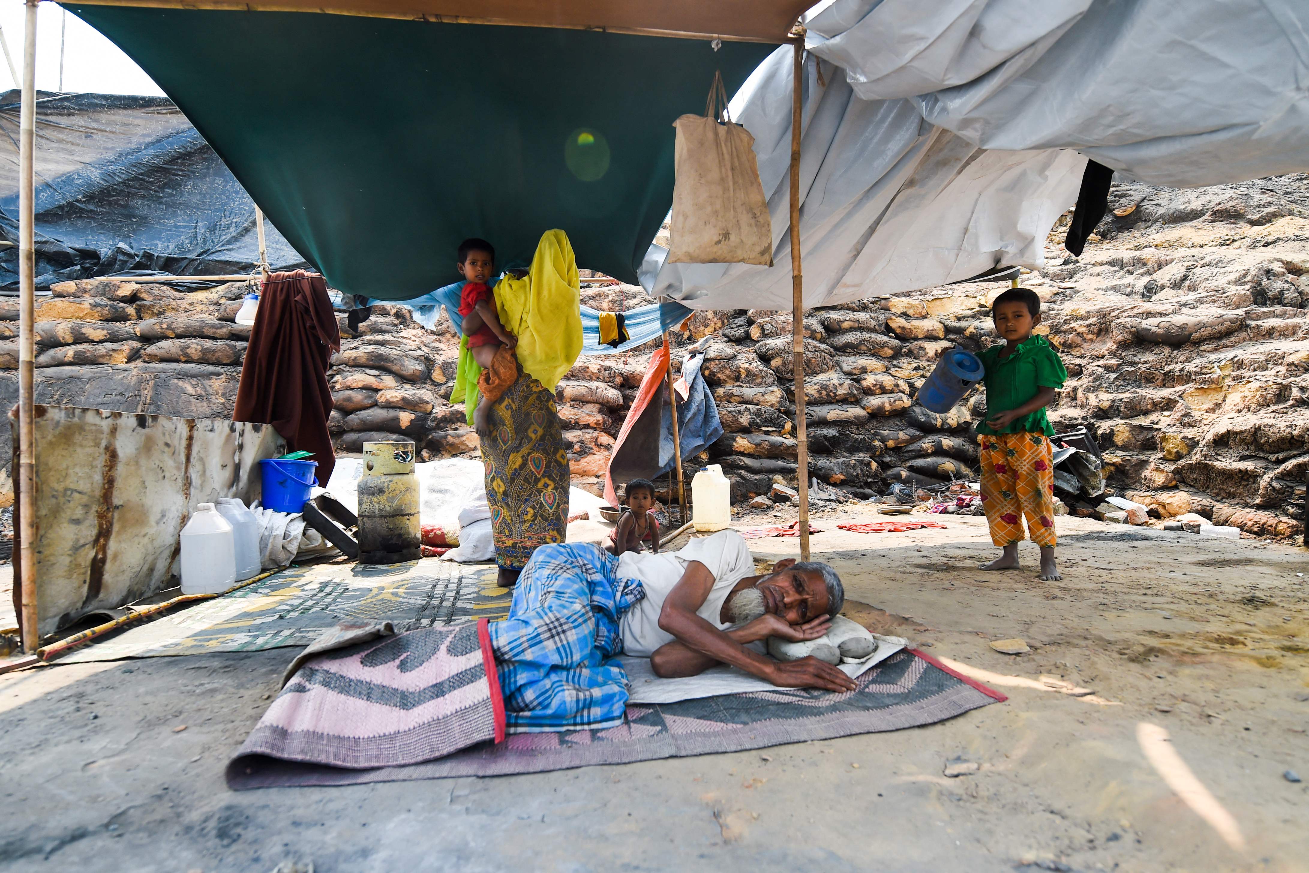 Sebuah keluarga Roingya beristirahat di tenda penampungan di Cox's Bazar, Bangladesh.
