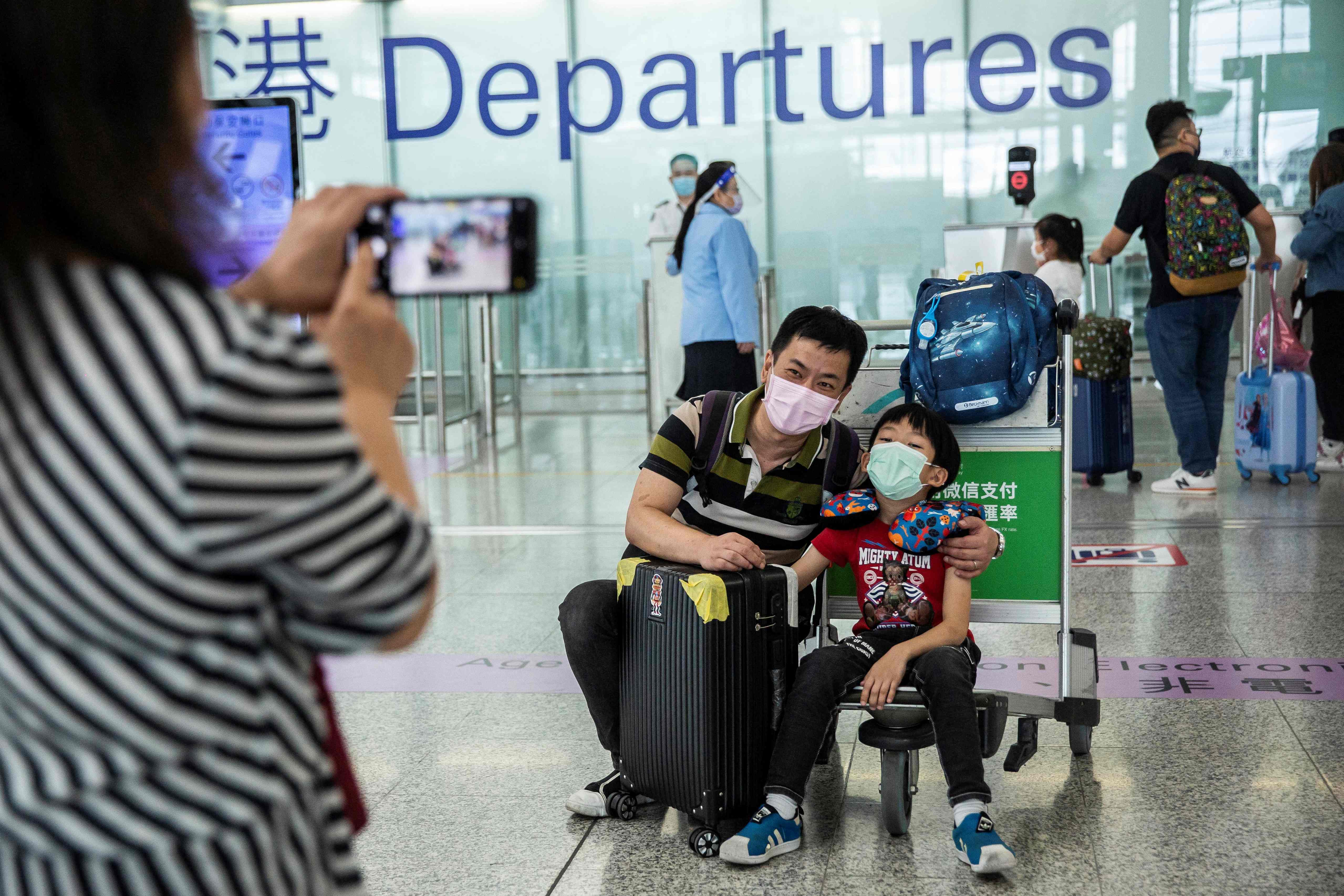 Keluarga mengambil foto di gerbang keberangkatan Bandara Internasional Hong Kong.