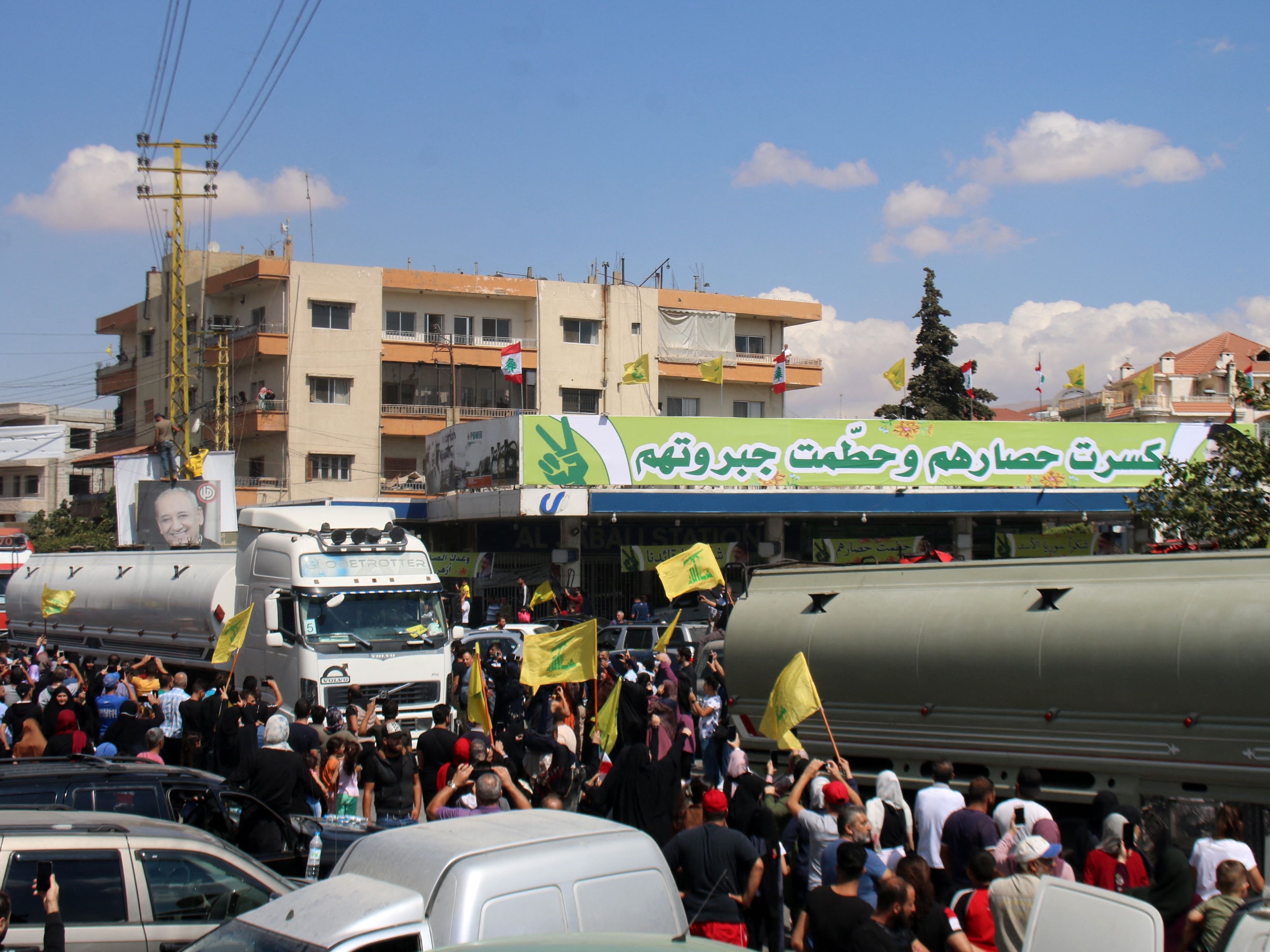 Orang-orang mengibarkan bendera gerakan Syiah Libanon, Hizbullah, saat menyambut kapal tanker yang membawa bahan bakar, Kamis (16/9).