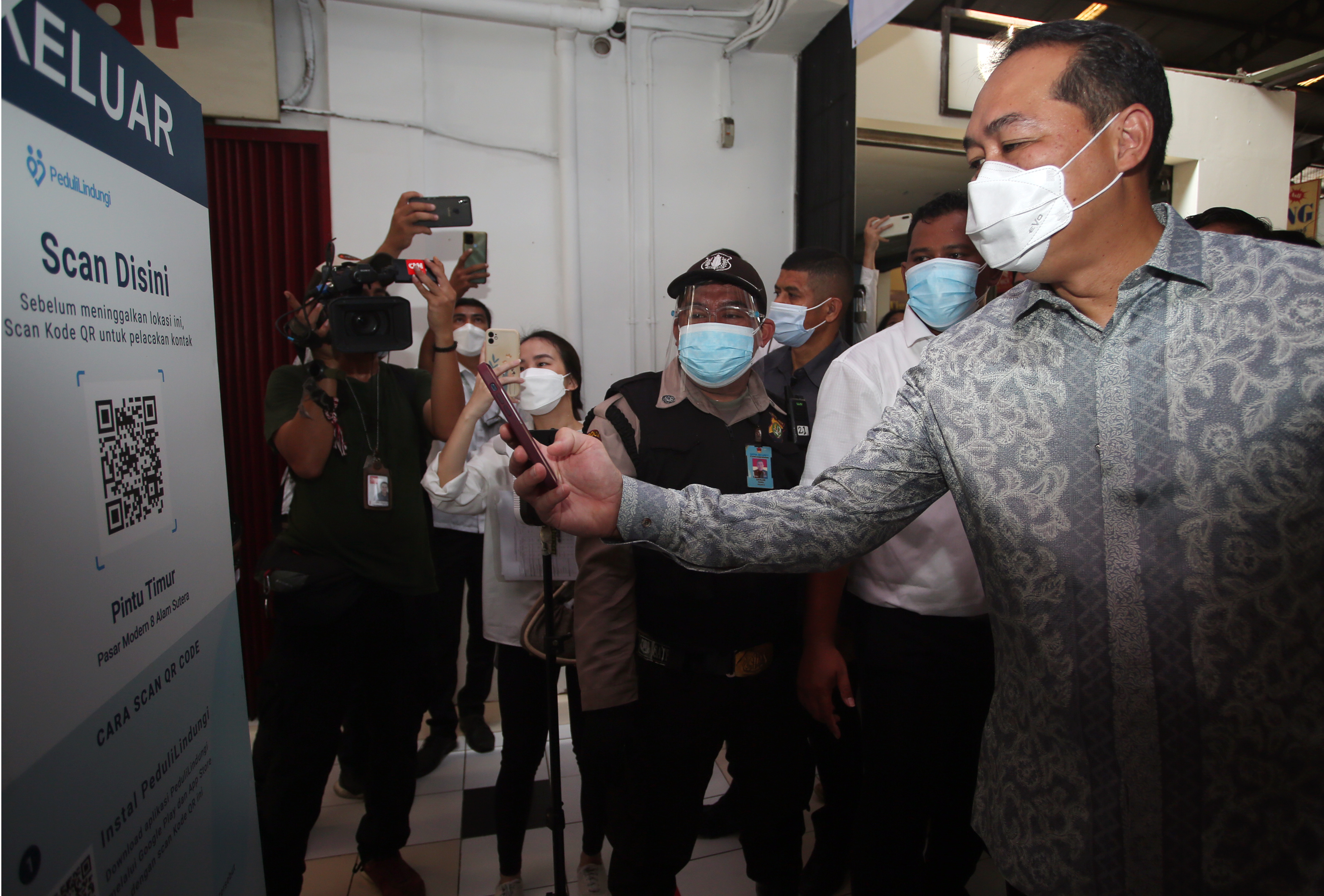 Menteri Perdagangan Muhammad Lutfi saat memindai aplikasi PeduliLindungi di Pasar 8 Serpong, Tangerang.